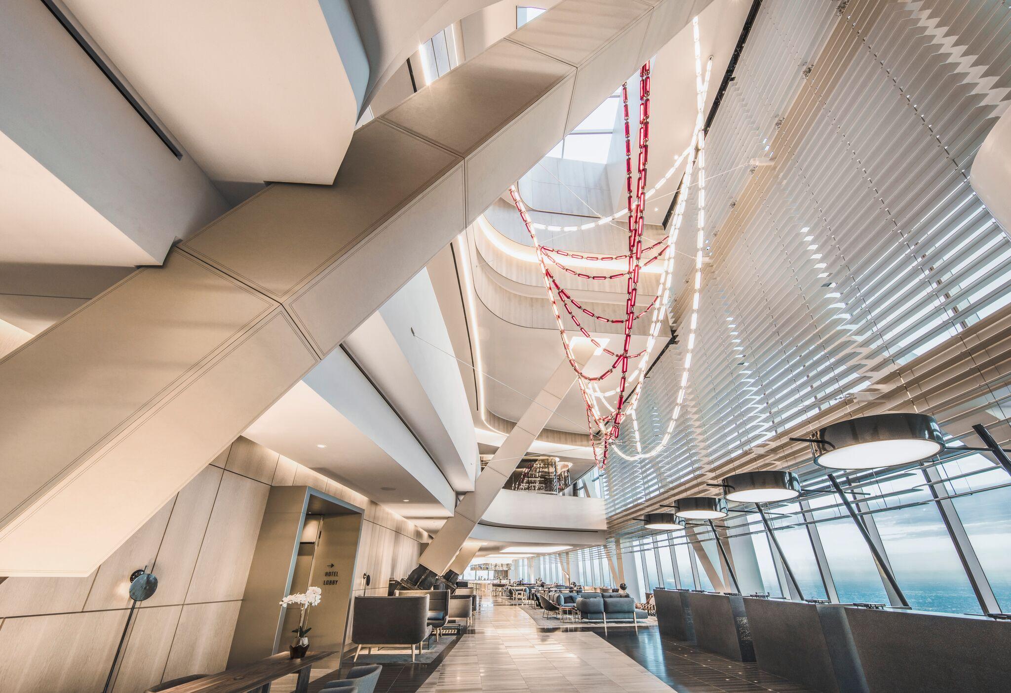 The airy lobby, with car light-inspired artwork draped from the ceiling