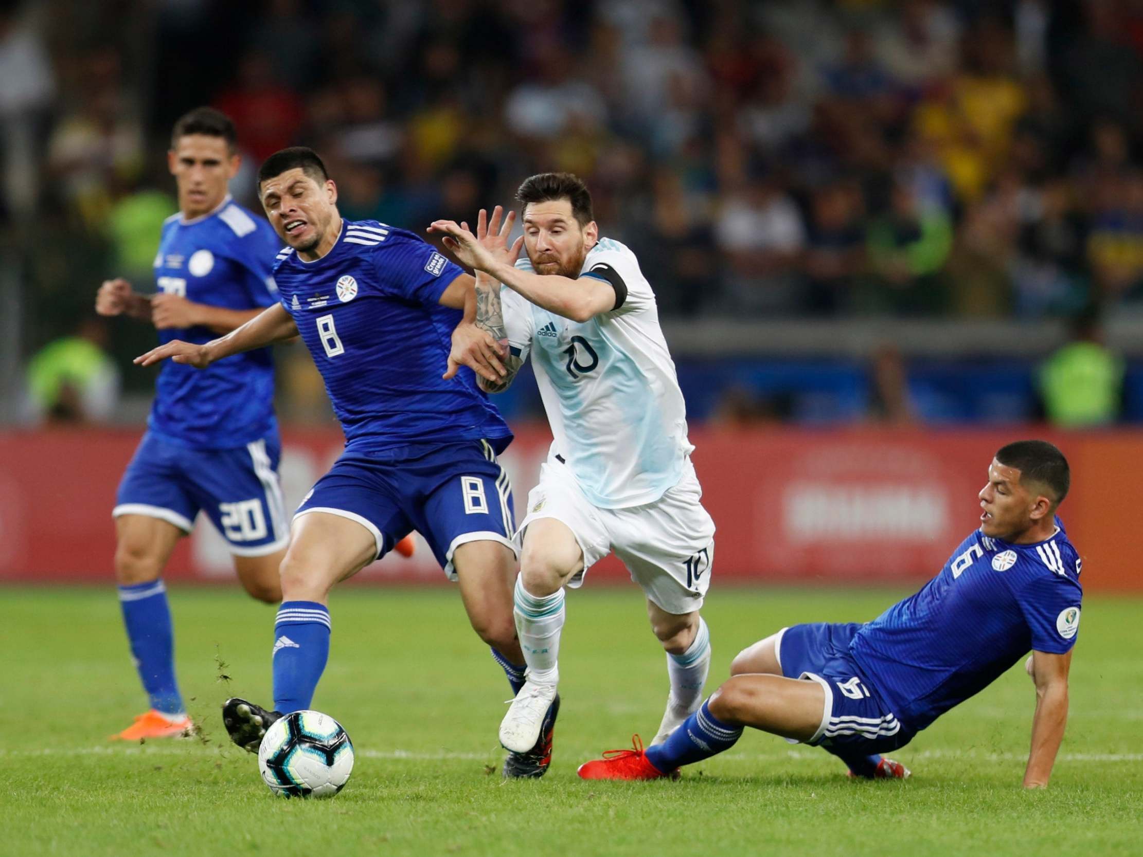 Lionel Messi is taken down by Paraguay