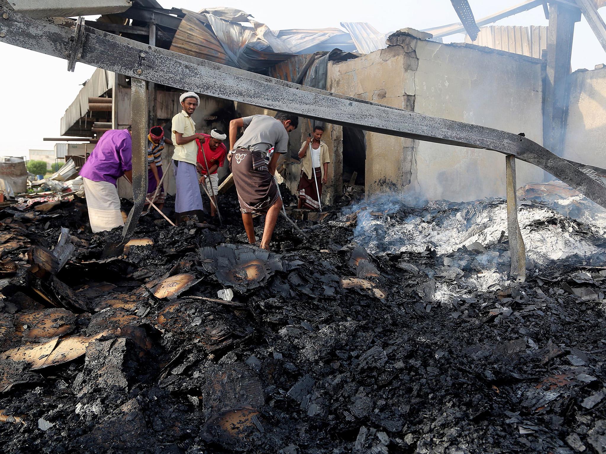 Yemeni men inspect the damages at a factory allegedly targeted by Saudi-led coalition’s airstrikes in the Red Sea town of Hodeidah on 27 July 2018