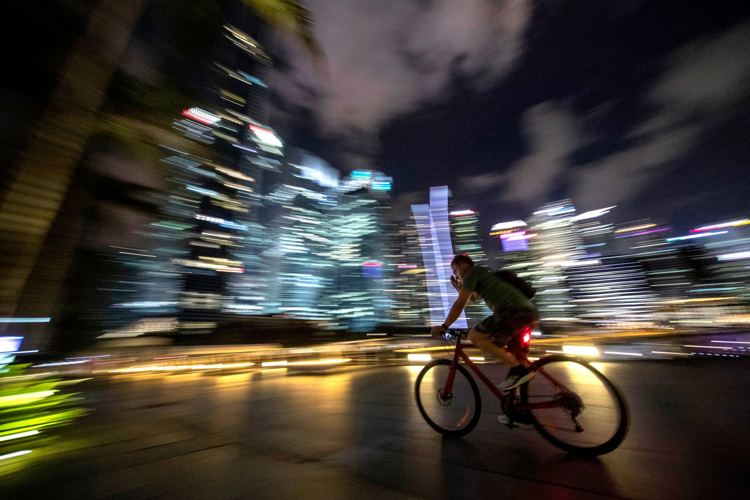 A cyclist rides past the brightly lit financial district casting skyglow in Singapore. A 2016 report by the Light Pollution Science and Technology Institute put Singapore as the country with the highest level of light pollution in the world, adding that it was 'not possible to view the Milky Way Galaxy anywhere in the country.'