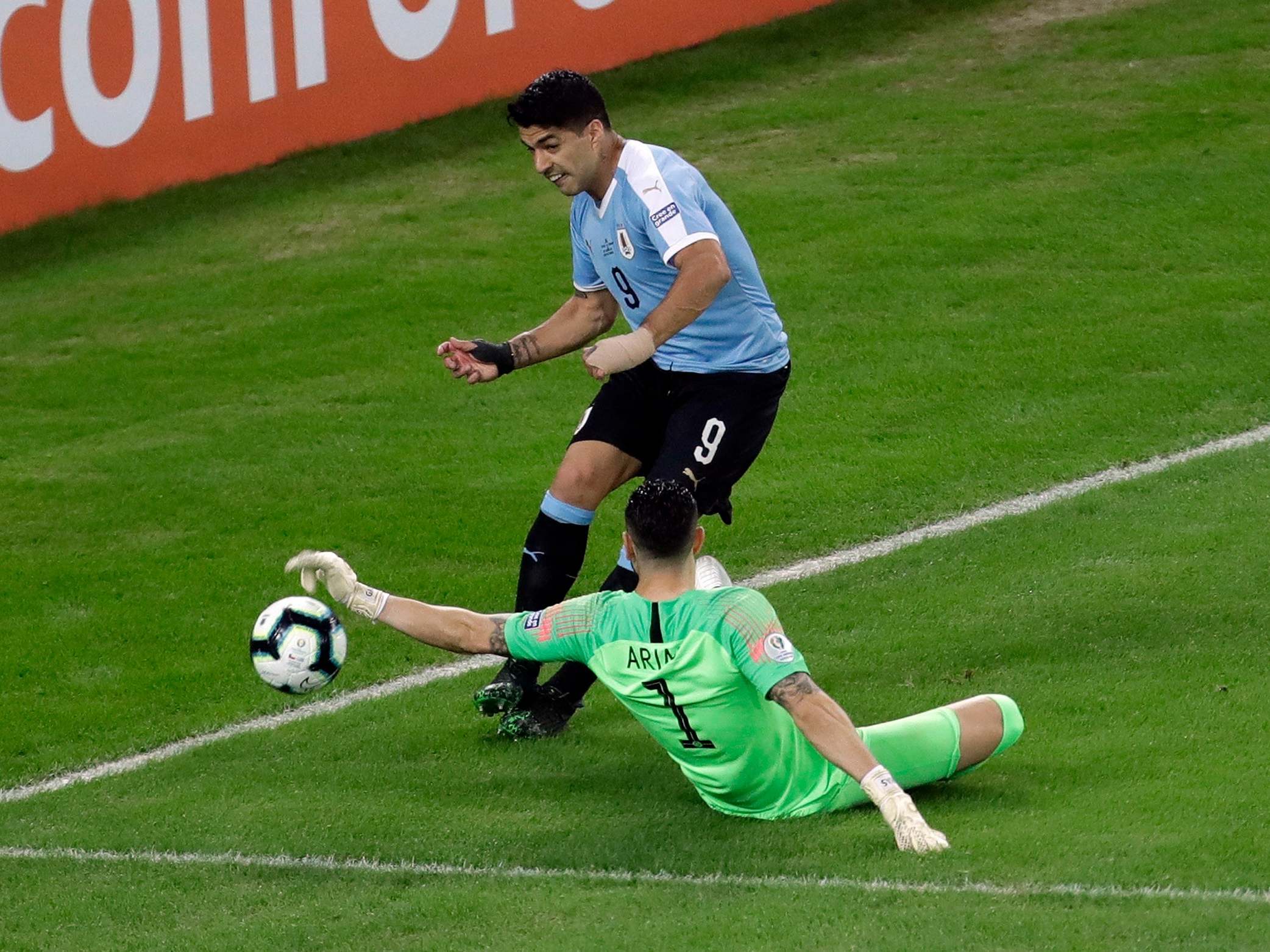 Arias blocks the cross from Suarez with his hand