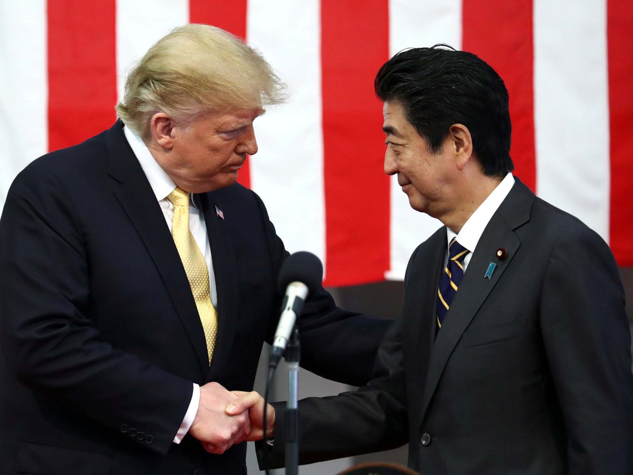 Donald Trump shakes hands with Shinzo Abe during a speech to Japanese and US troops in Yokosuka, south of Tokyo, in May