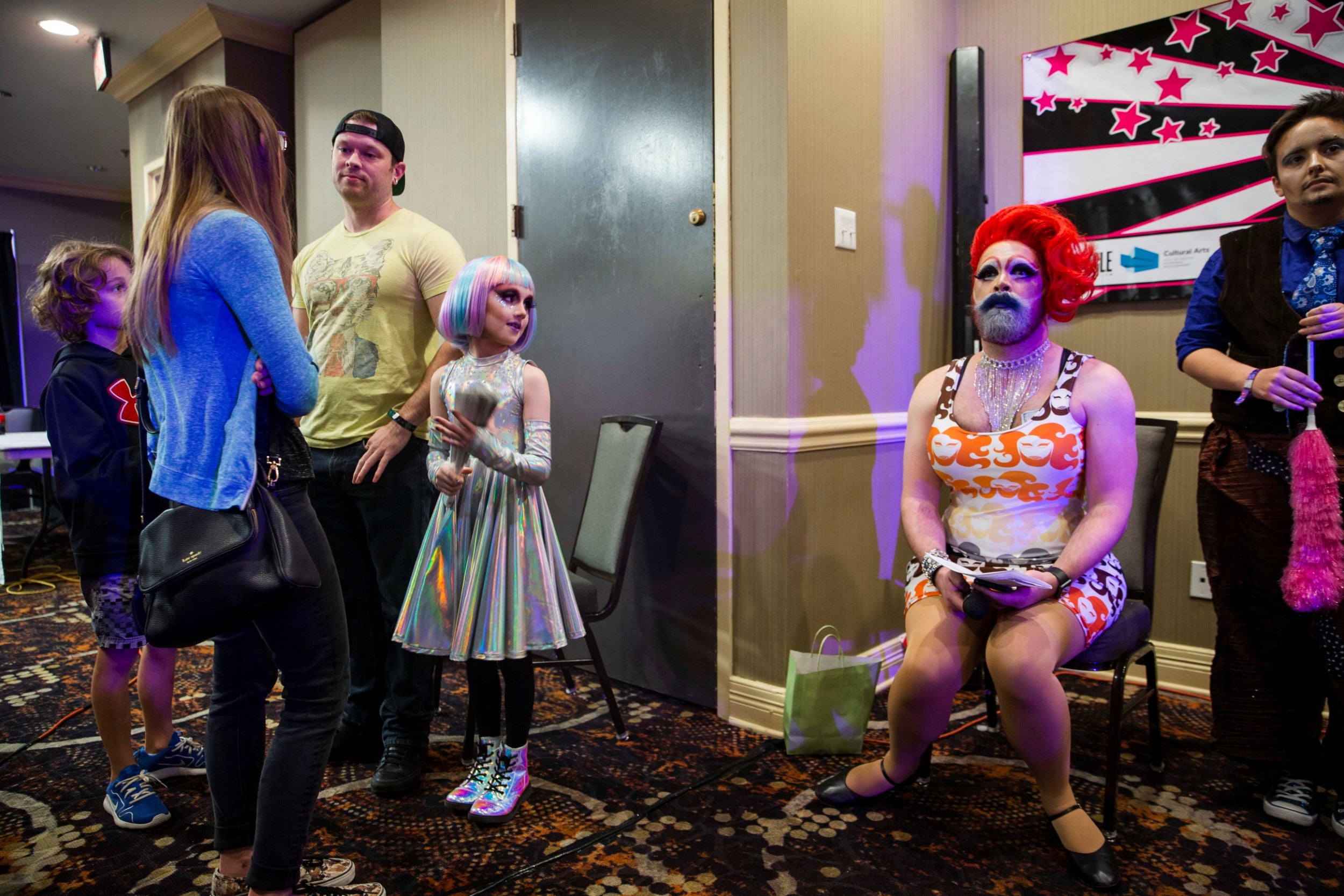 Keegan accompanied by his family, glances at another performer during the Austin International Drag Festival 2018