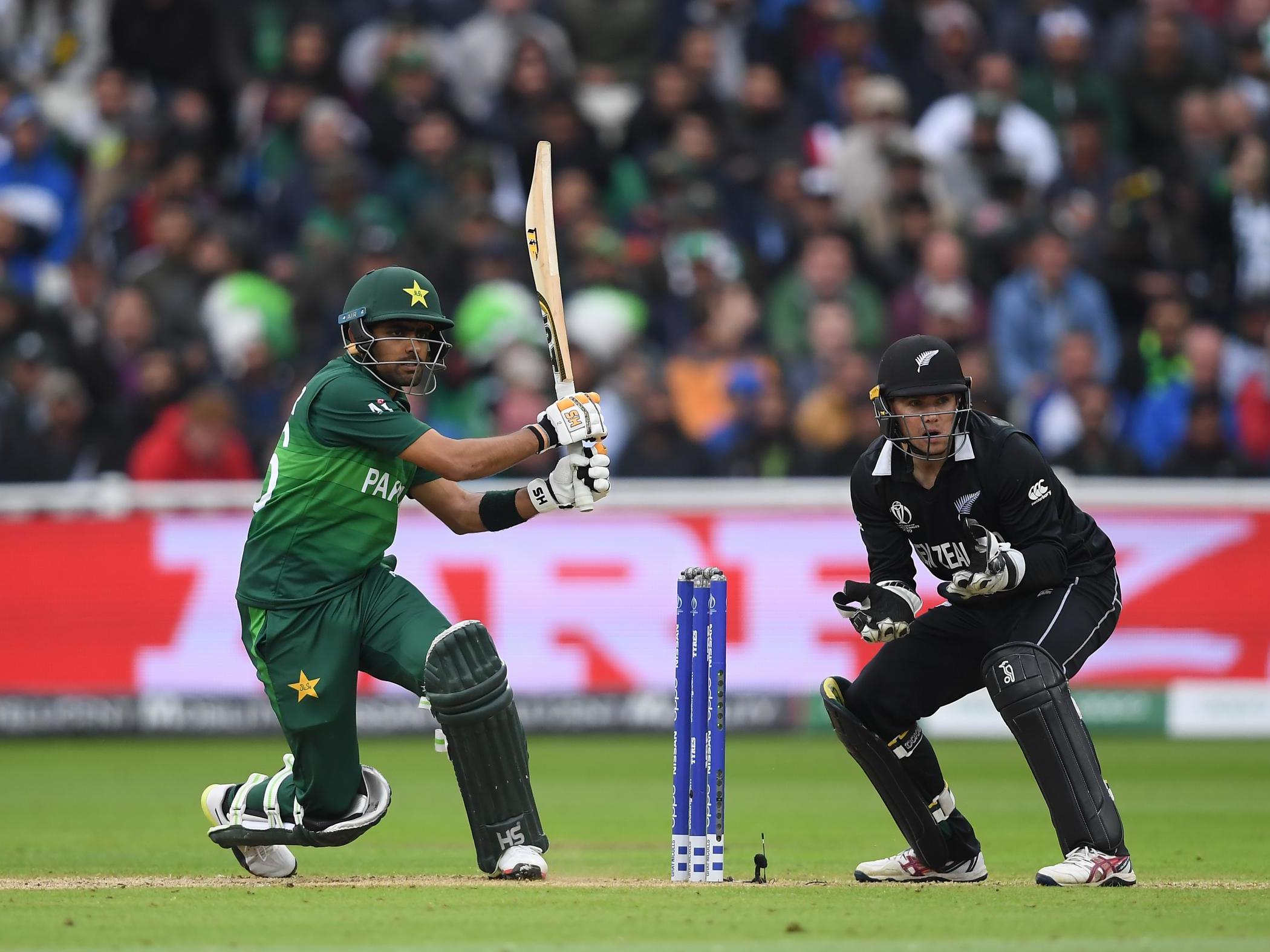 Babar Azam plays a shot as Tom Latham looks on