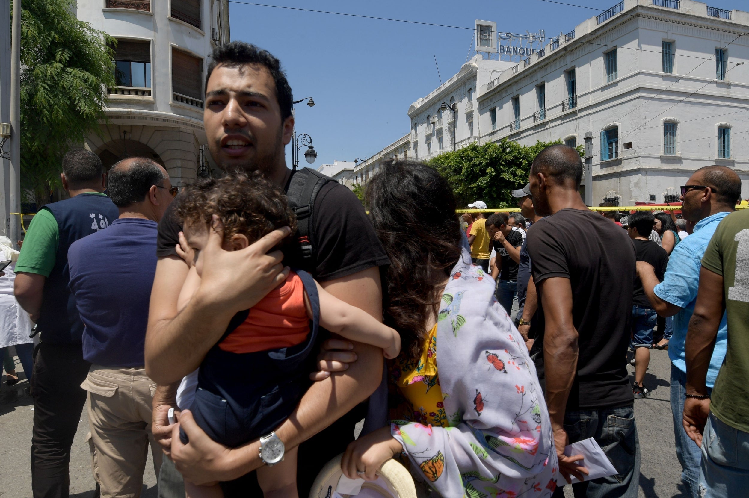 Tunisian civilians react at the site of an attack in the Tunisian capital's main avenue Habib Bourguiba