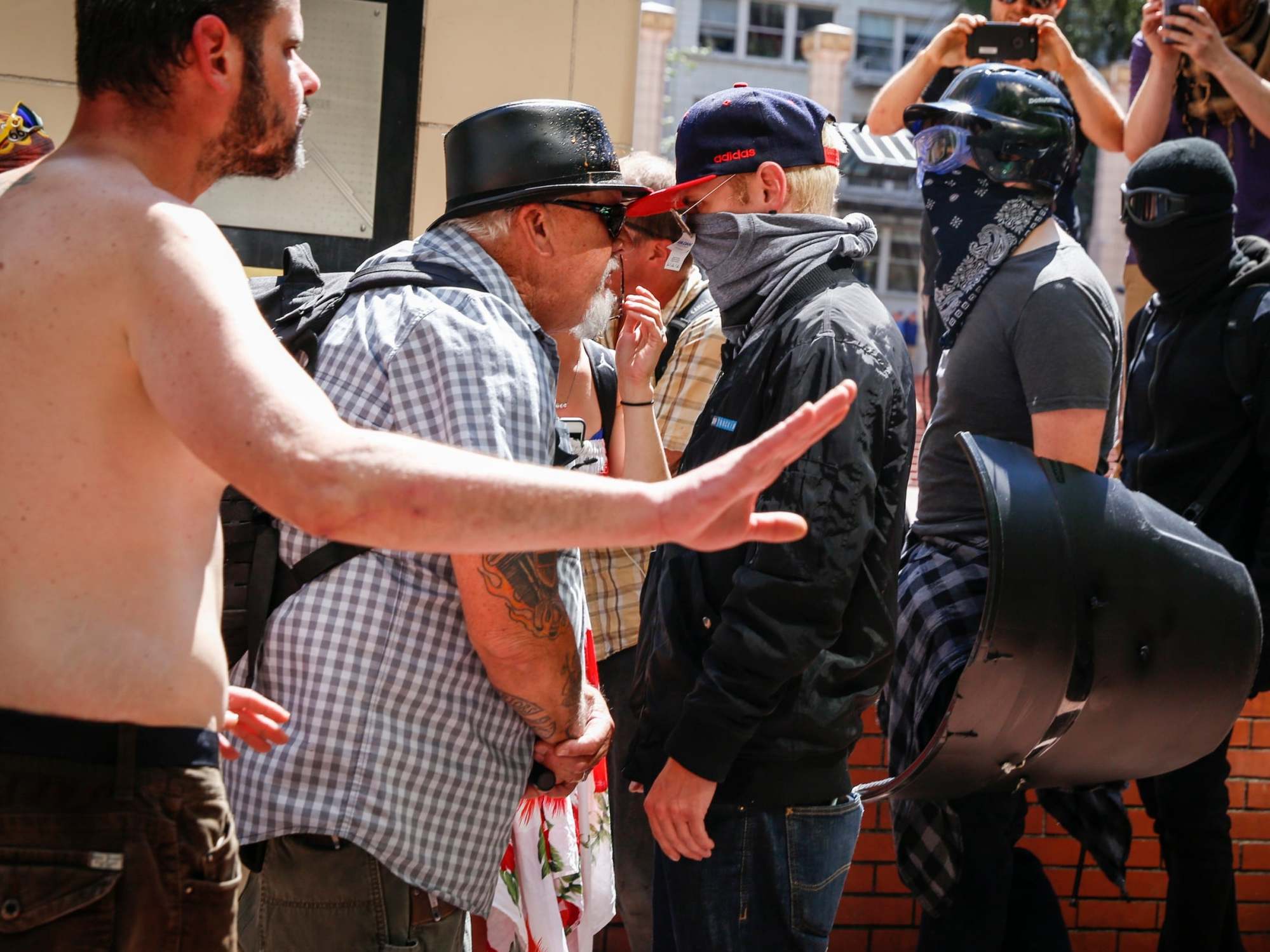 An unidentified right aligning man faces off with Rose City Antifa members at Pioneer Courthouse Square on 29 June in Portland, Oregon