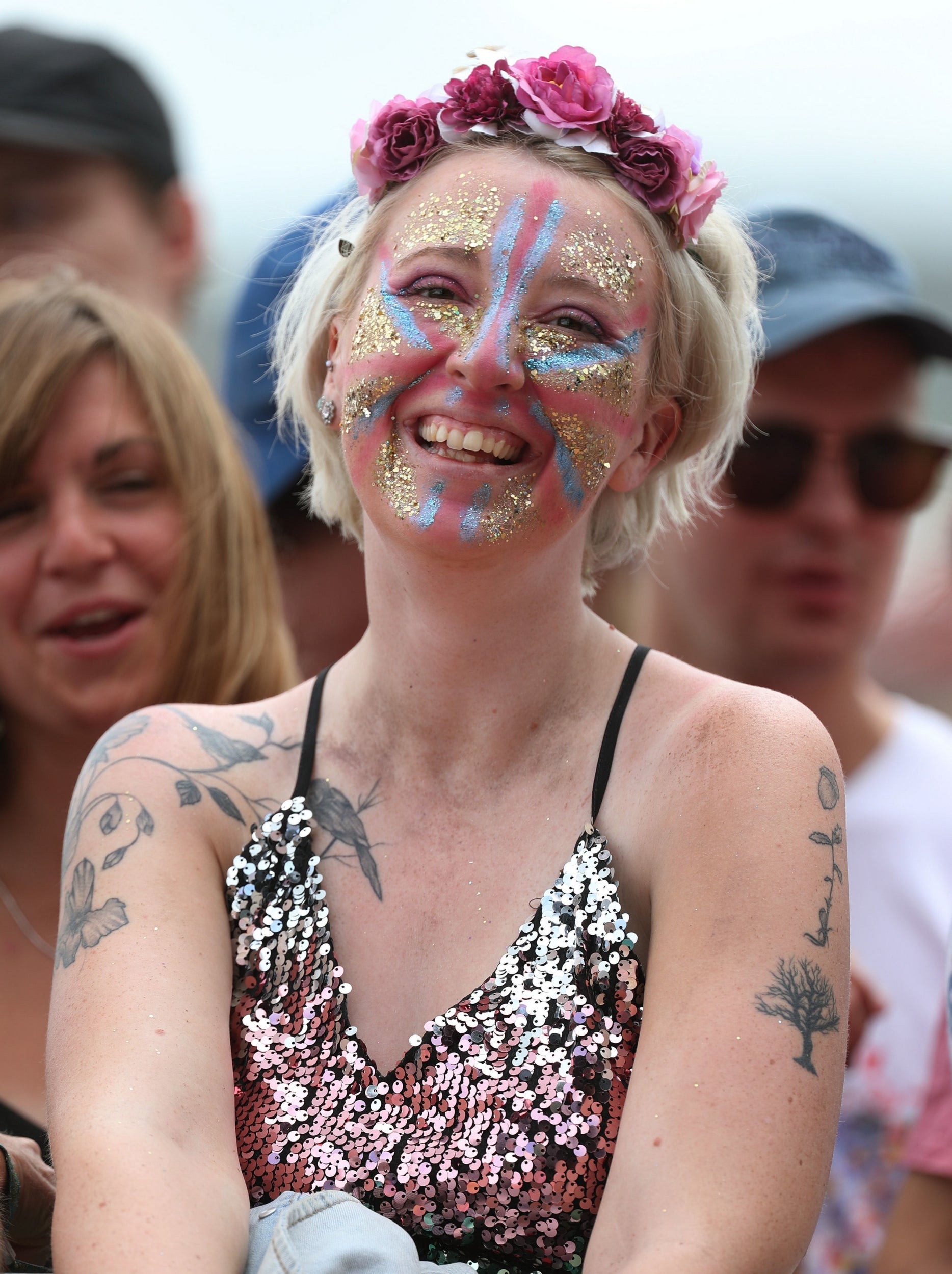 This attendee ticks all the boxes: flowers, face paint, glitter, huge smile.