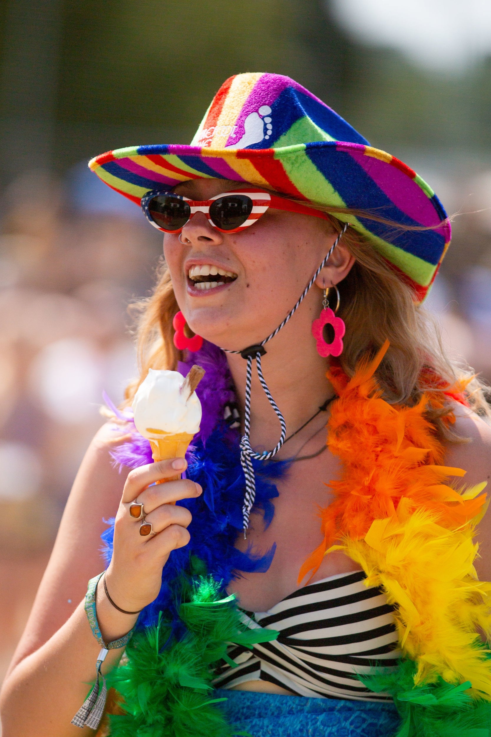 Rainbow hat, rainbow feathers and ice cream make the perfect stand-out ensemble.