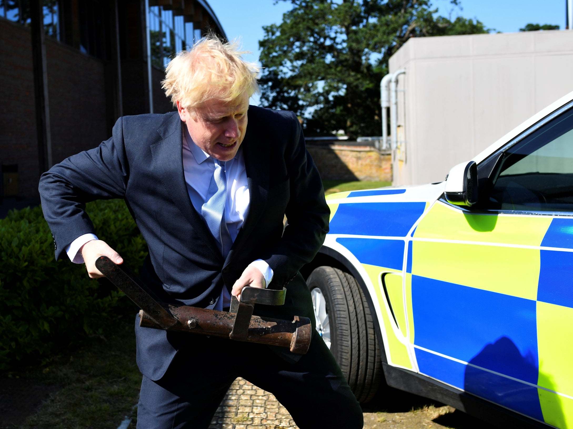 Boris Johnson holds a battering ram during a visits to Thames Valley Police Training Centre on Wednesday (REUTERS)