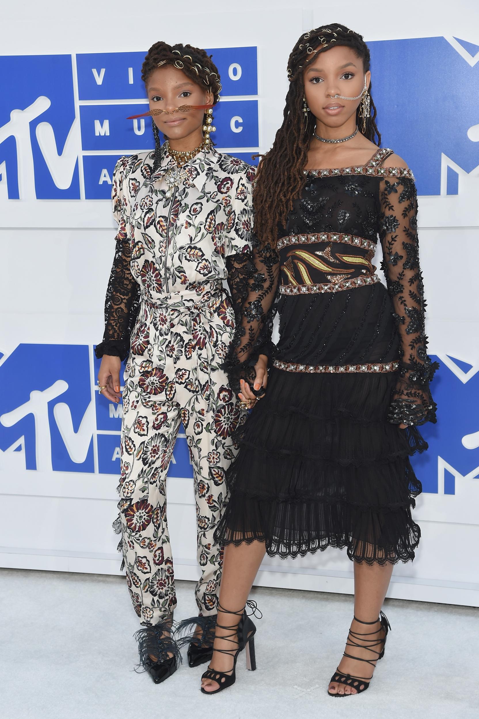 Chloe sported a patterned white, red and black jumpsuit with lace sleeves for the 2016 MTV Video Music Awards in New York, while Halle wore a midi-length lace tiered black dress with strappy heels.