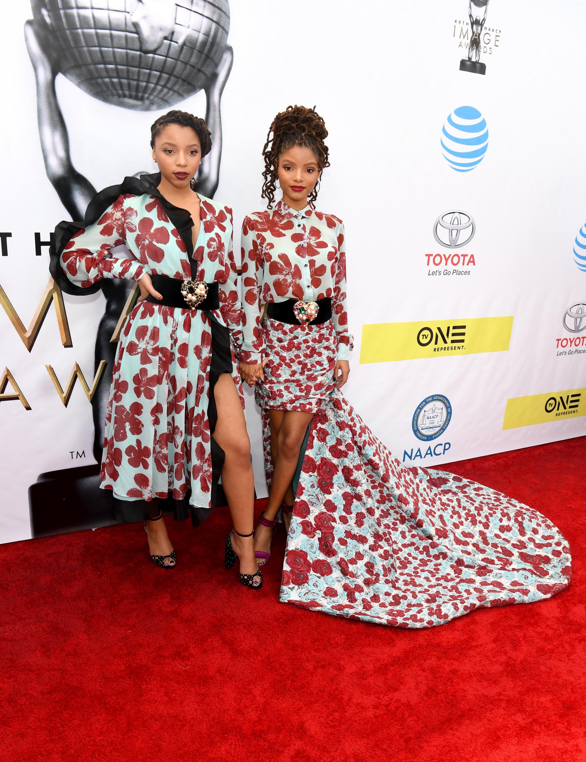 Chloe and Halle matched in aquamarine dresses printed with red florals to the 48th NAACP Image Awards in 2017. Chloe wore a mini version of the print with an oversized black tulle lining, while Halle wore a mini dress shirt dress design with a long train.