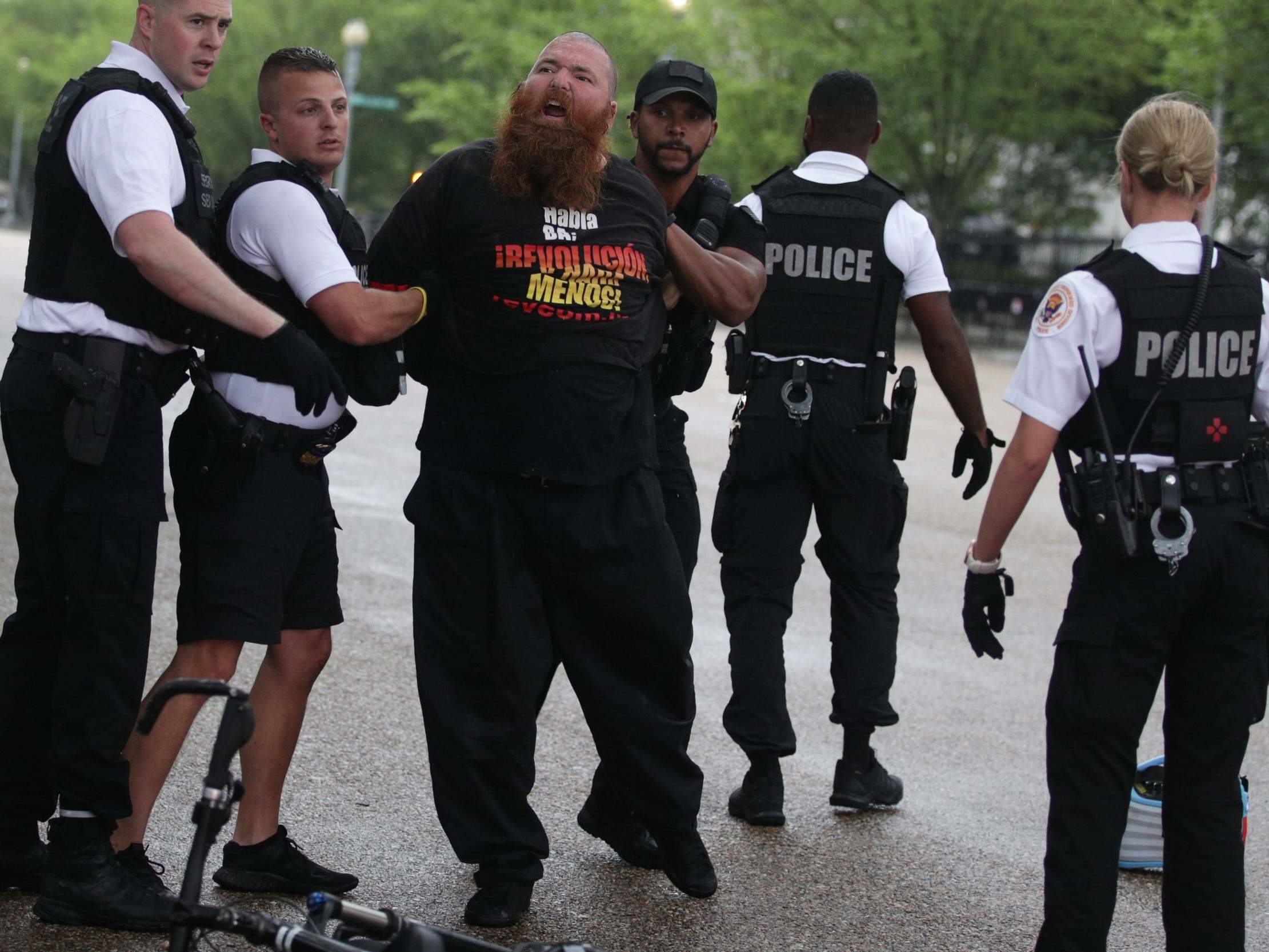 Members of the US Secret Service detain a man after an attempted flag burning in front of the White House