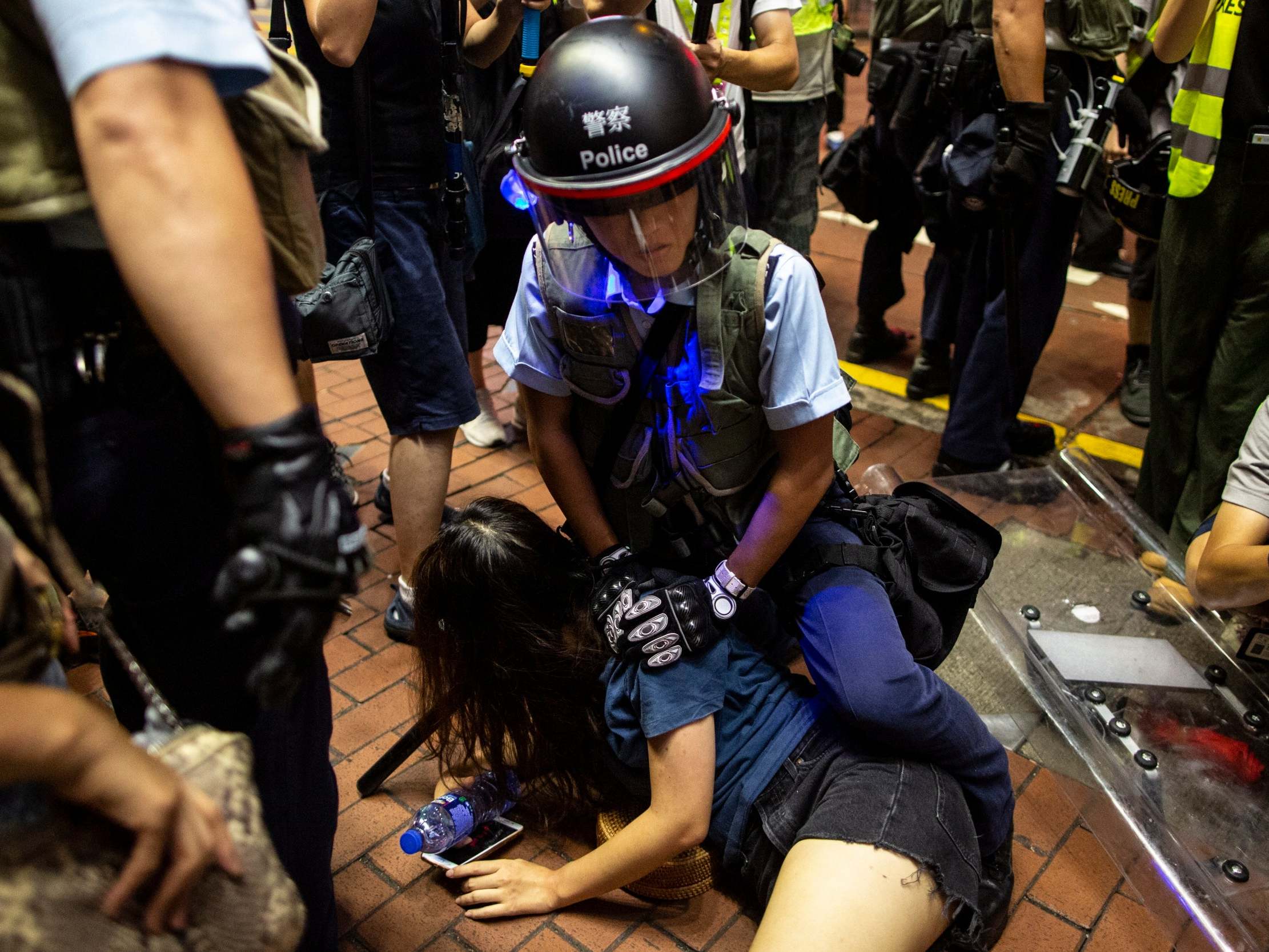 A riot police officer detains anti-extradition bill protester on Sunday