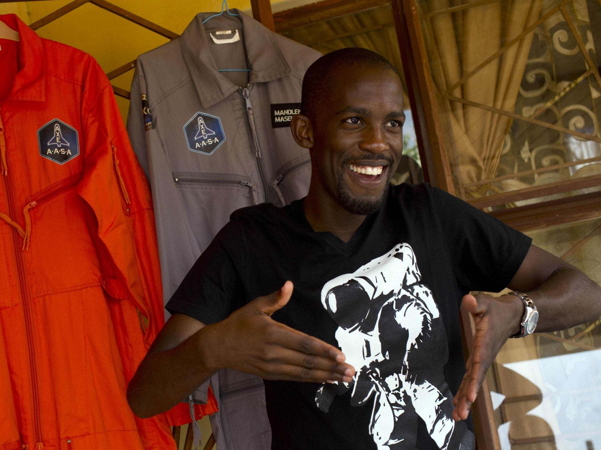 Mandla Maseko speaks to journalists in front of two NASA spacesuits in Mabopane, north of Pretoria, in January 2014