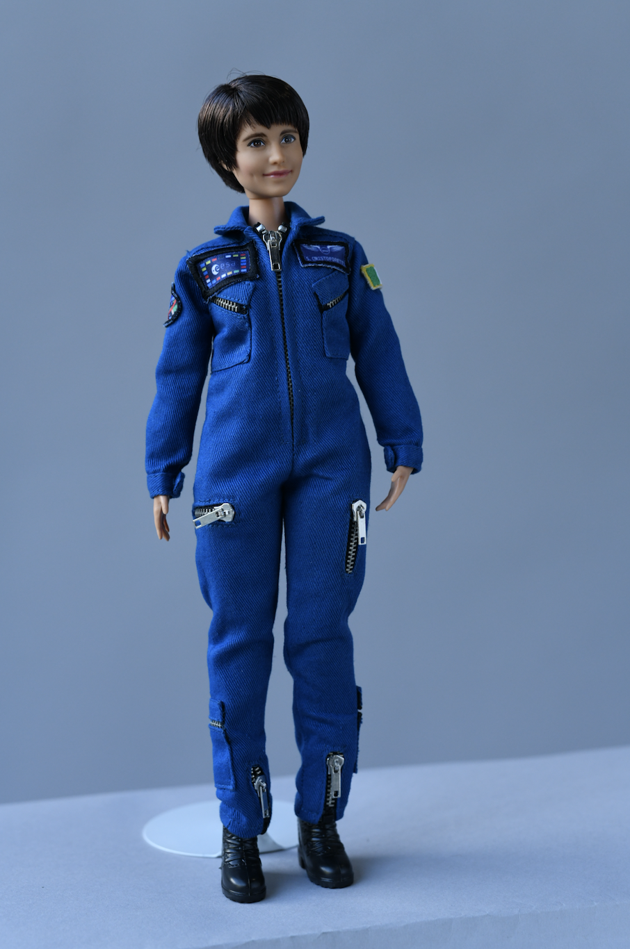 The doll's second outfit is. an ESA blue flightsuit complete with ESA patches (Barbie)