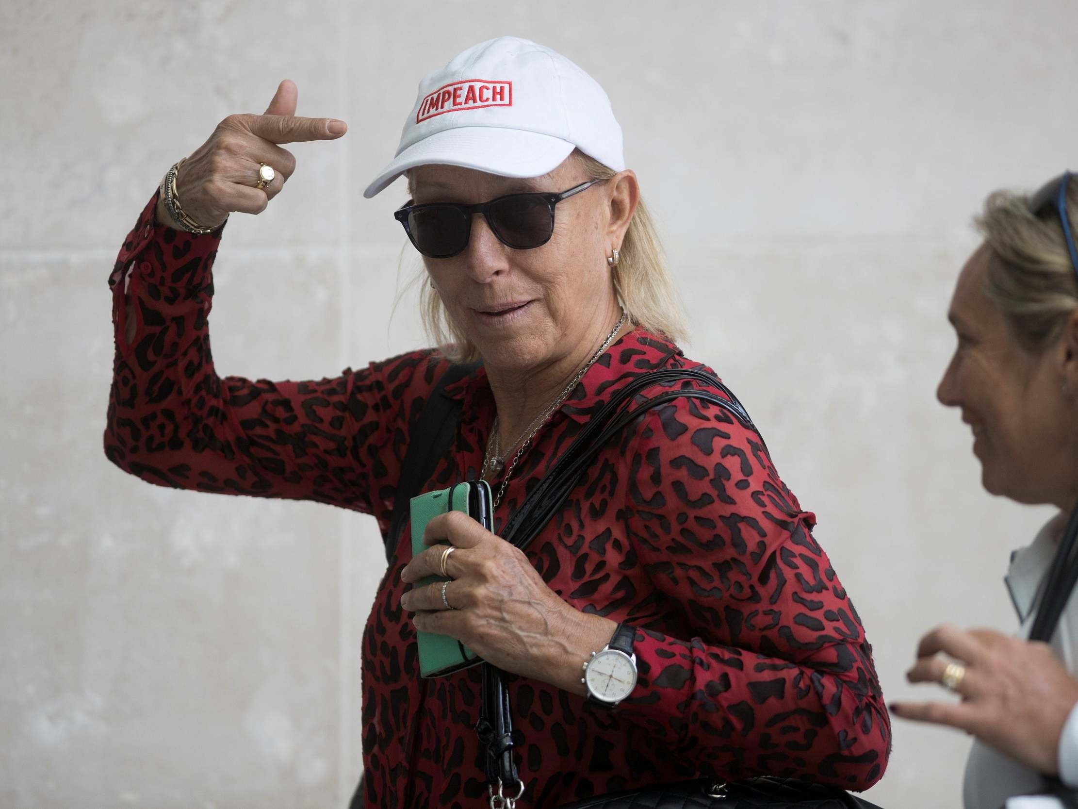 Former tennis professional Martina Navratilova points to her cap