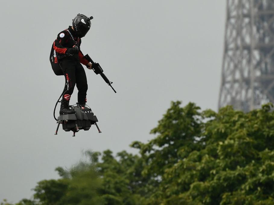 Zapata CEO Franky Zapata flies a jet-powered hoverboard or 'Flyboard prior to the Bastille Day military parade down the Champs-Elysees avenue in Paris on 14 July, 2019