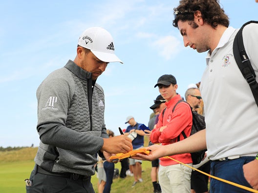 Xander Schauffele signs autographs during a practice round in Portrush