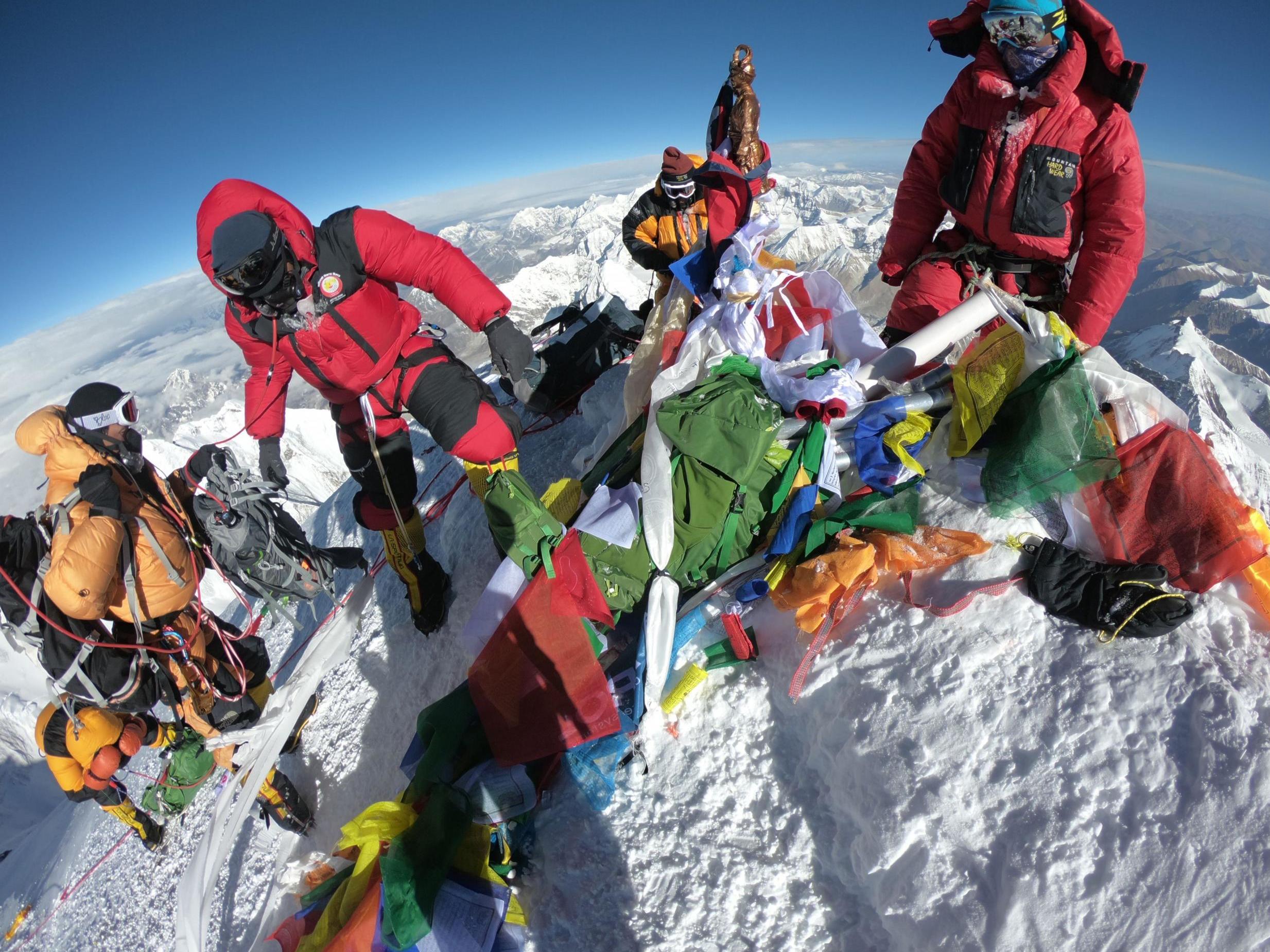 Mountaineers and sherpas gather at the summit of Mount Everest after ascending the south face from Nepal