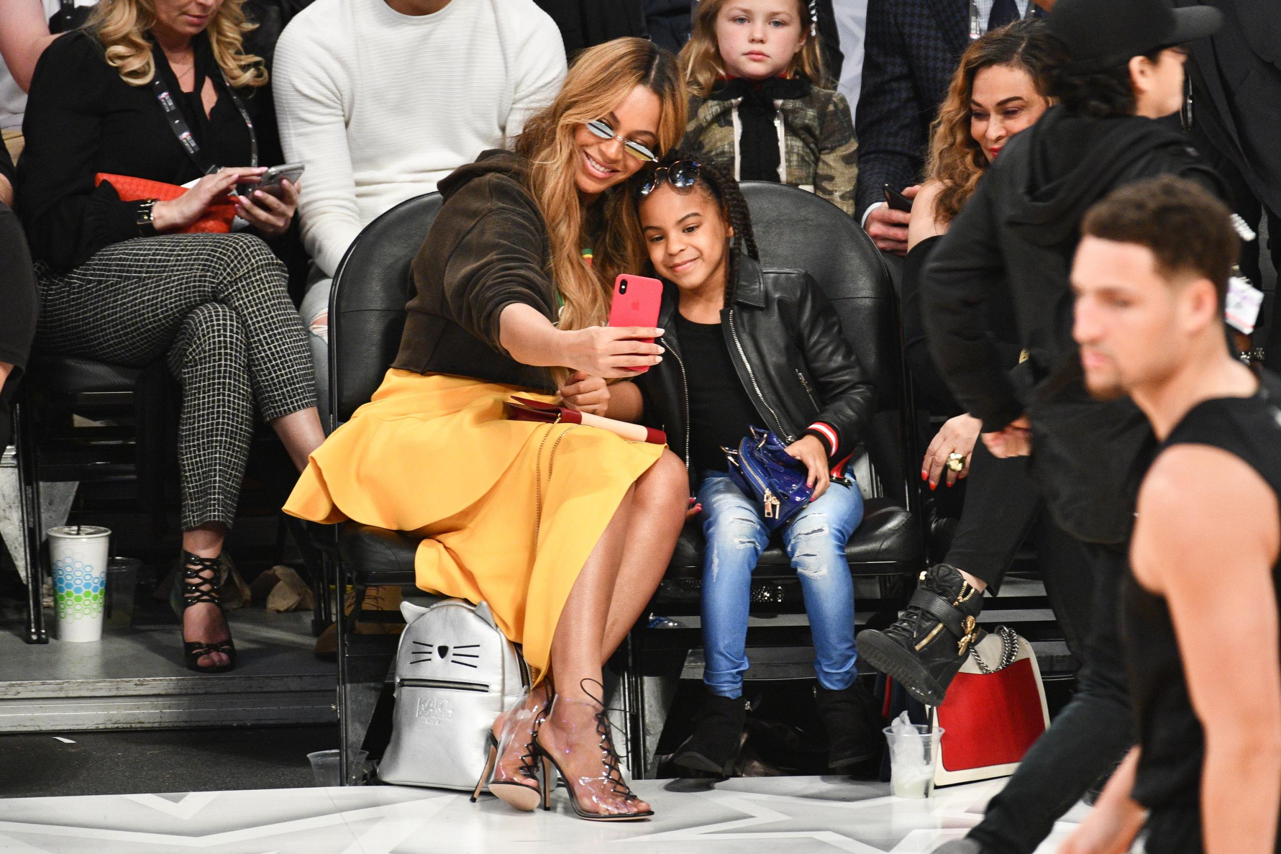 The pair were all smiles as they attended the 67th NBA All Star Game: Team LeBron versus Team Stephen at Staples Centre in Los Angeles, California in February 2018. Both opted for casual looks, Beyoncé in a yellow skirt and brown jumper and Blue Ivy in a pair of jeans, black boots and a black jacket. They both donned sunglasses as they took a selfie courtside.