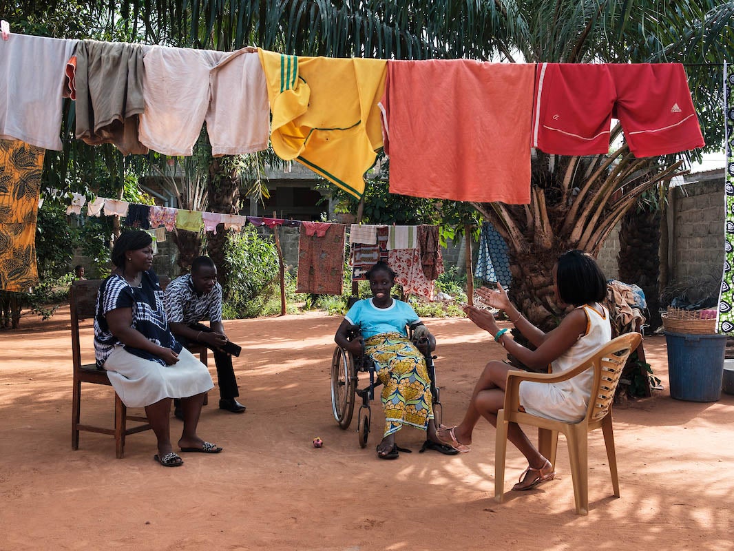 Grace (right) and her friend Ismael visiting Selasse, who has sickle-cell disease, and her mother. Selasse has difficulty speaking and is partially paralysed as a result of a stroke, which is one of the risks of the disease