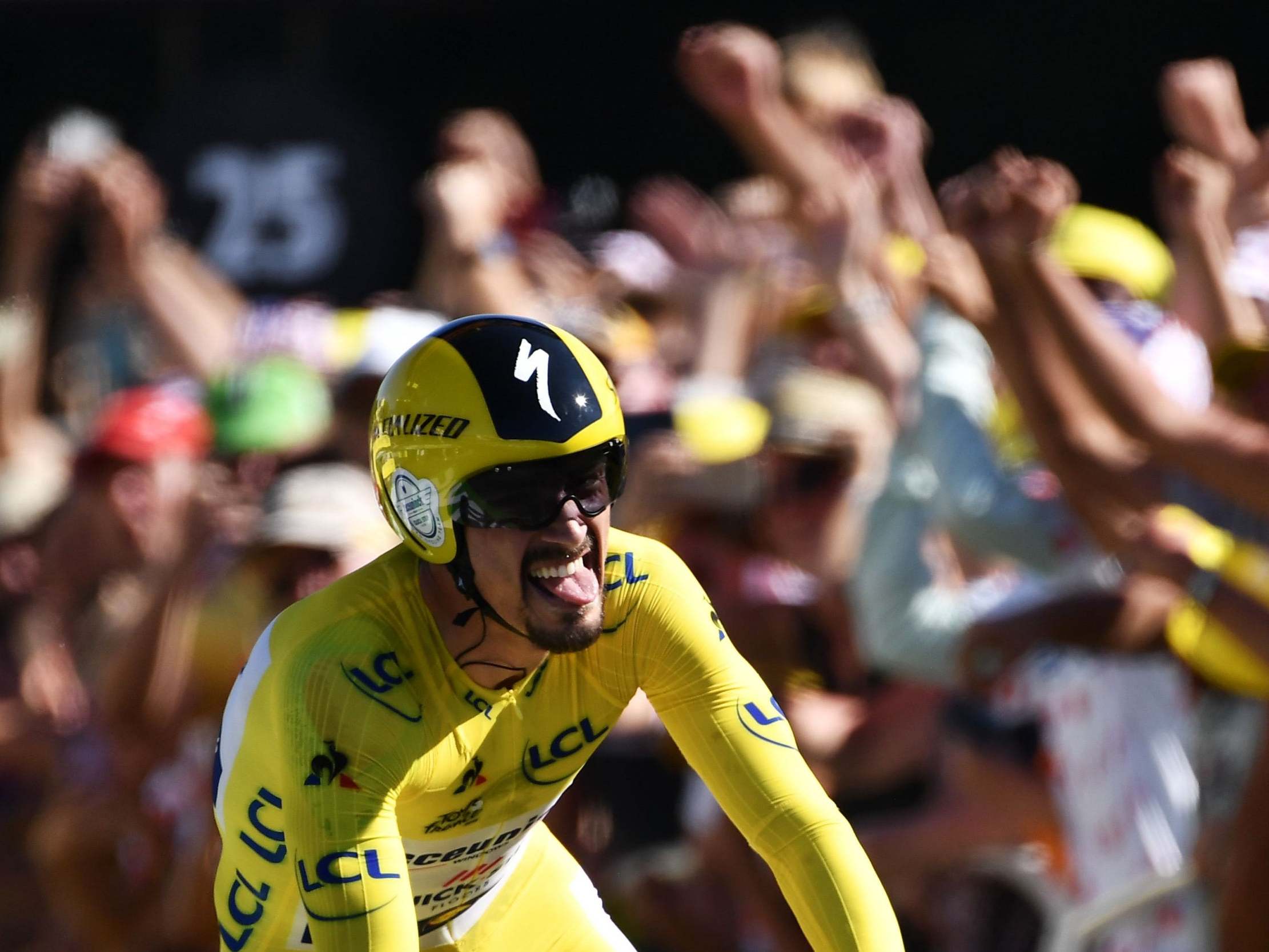 Julian Alaphilippe celebrates as he crosses the time-trial finish line