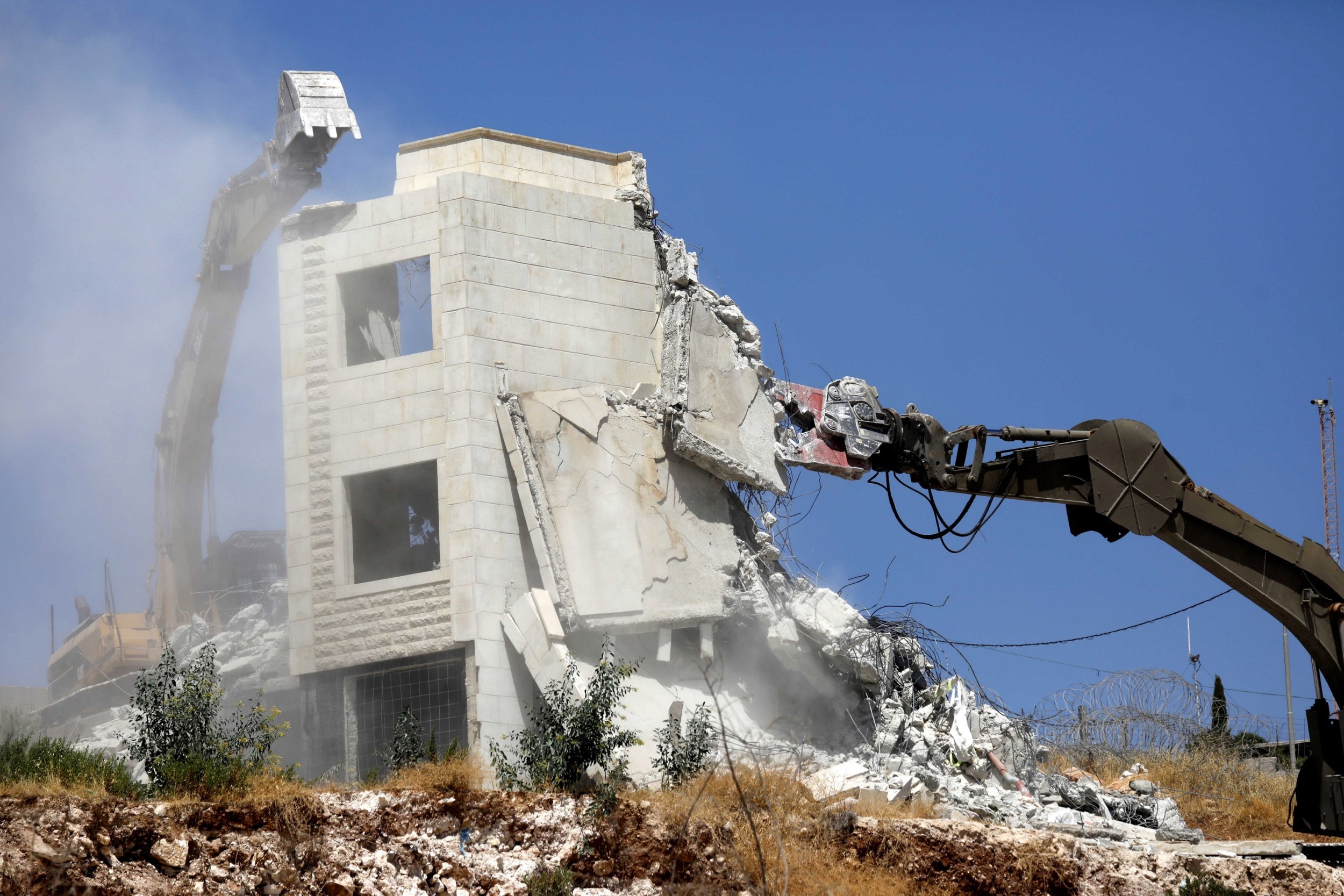 An Israeli army excavator demolishes a building in the Palestinian village of Sur Baher