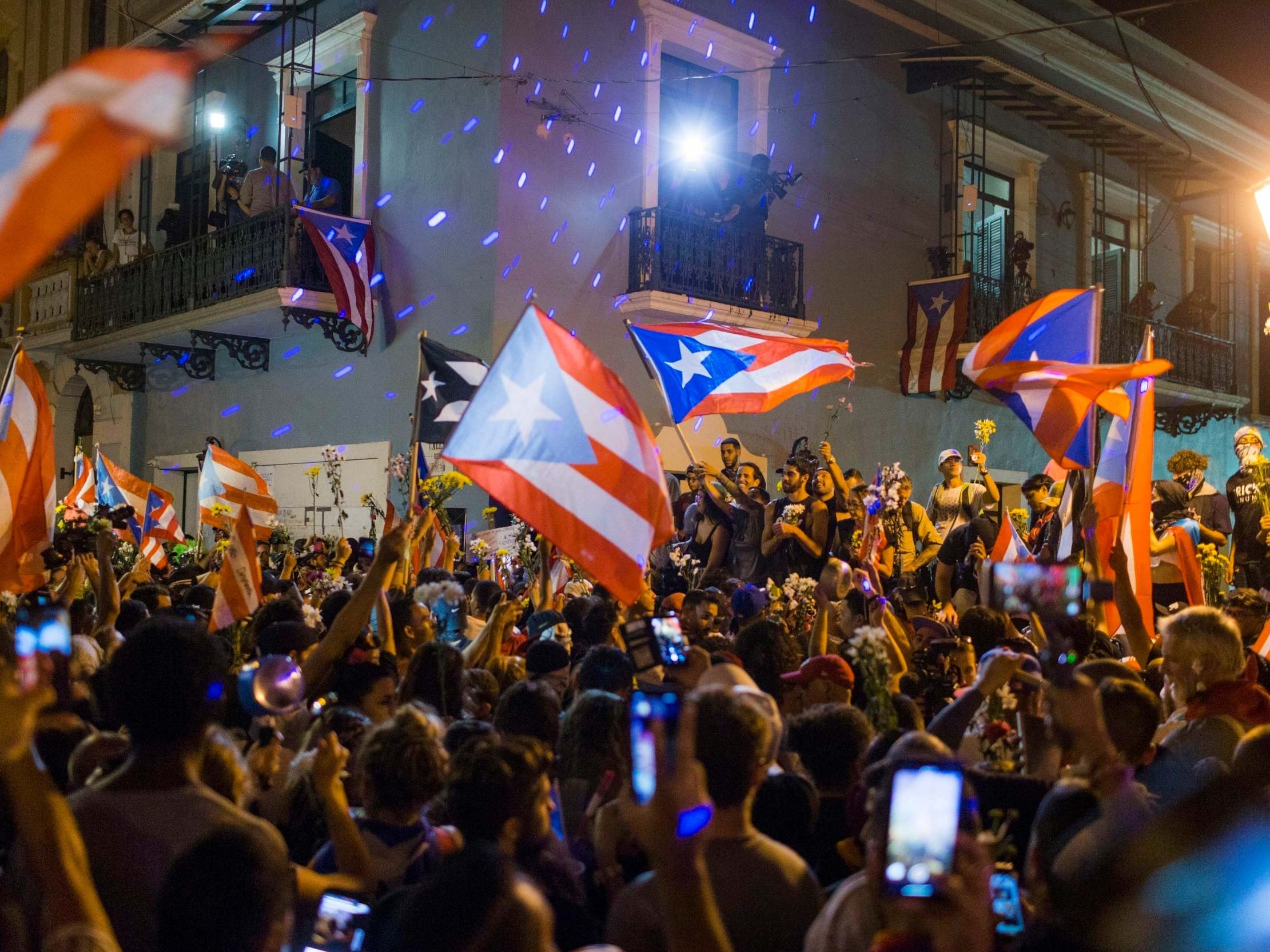 People celebrate outside the governor's mansion after Ricardo Rossello announced his resignation