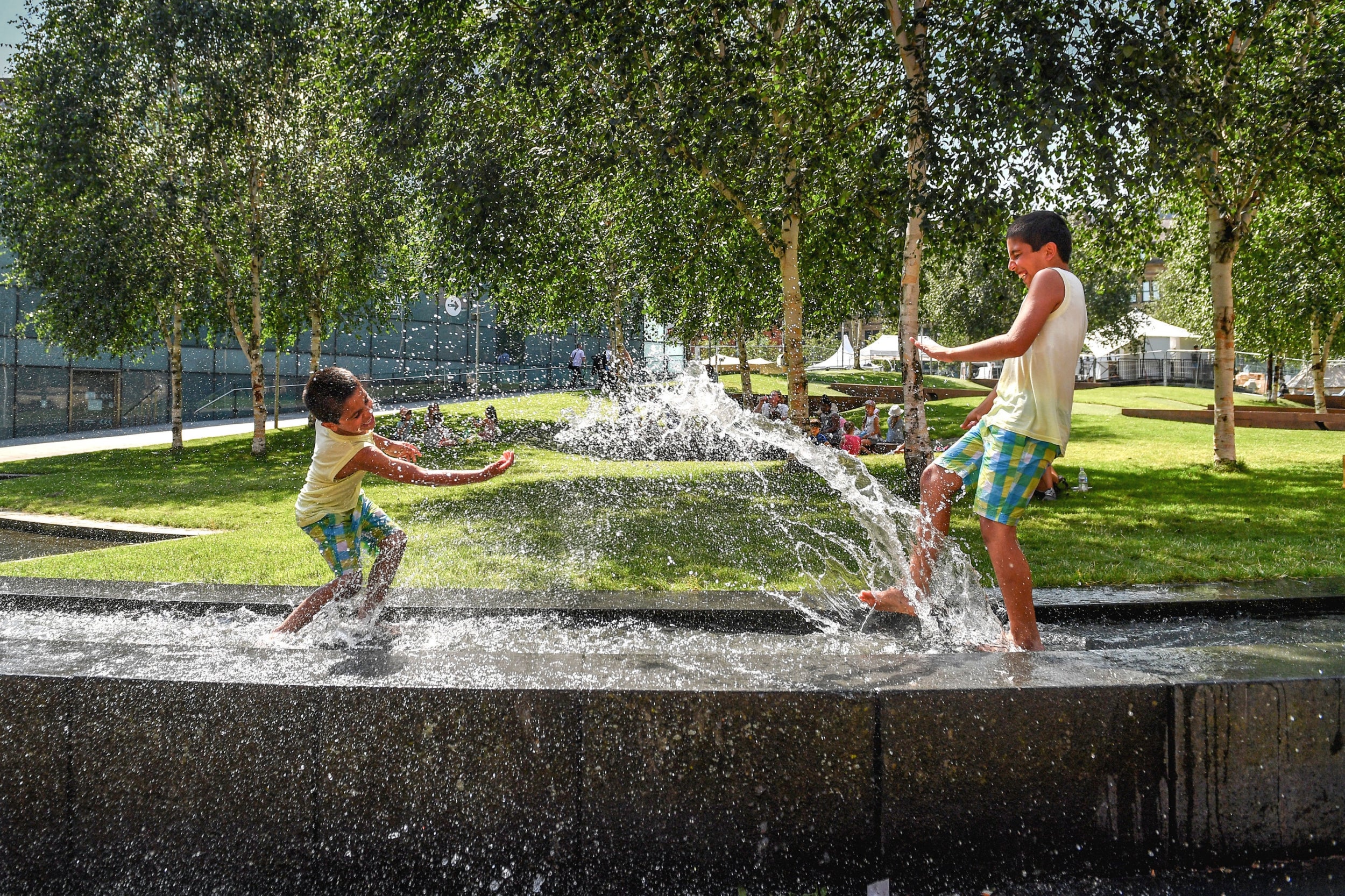 Hamza and Haris splash in the water feature beside the National Football Museum