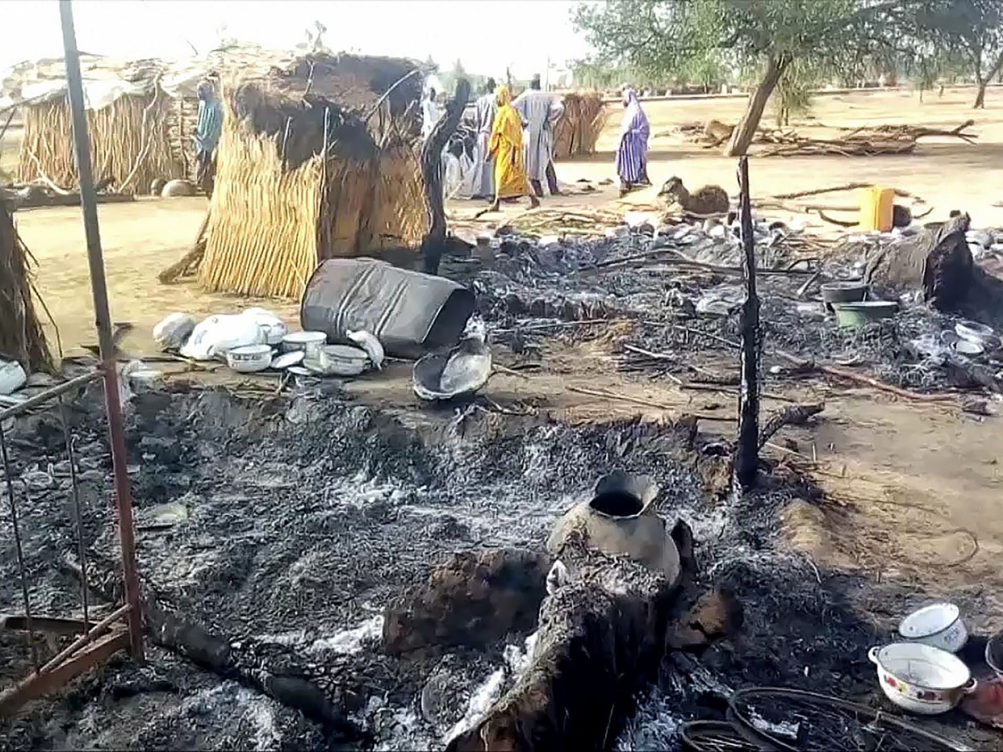 Smoldering ashes are seen on the ground in a village near the city of Maiduguri following a suspected attack by Boko Haram