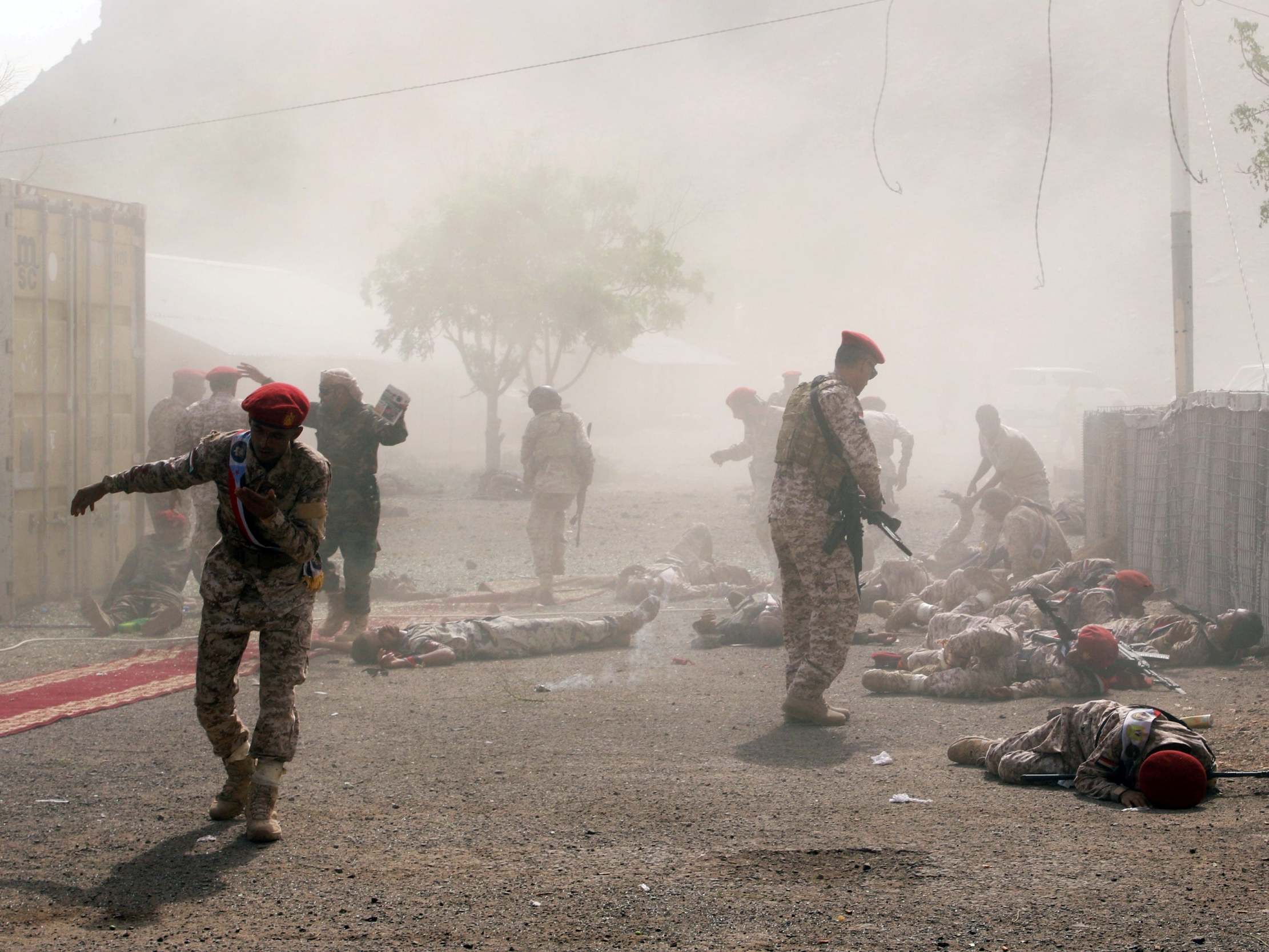 Soldiers lie on the ground after a missile attack on a military parade during a graduation ceremony for newly recruited troopers in Aden, Yemen