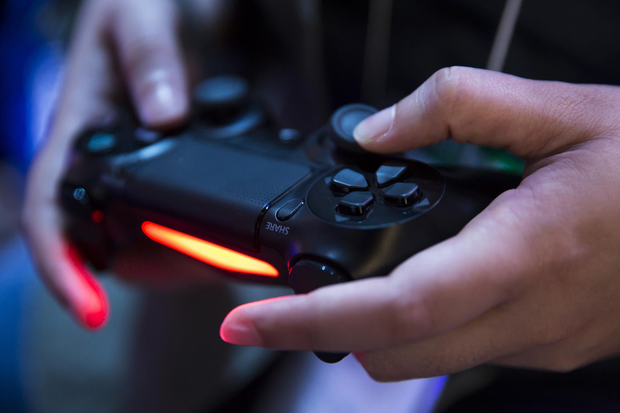 An attendee plays a video game on the PlayStation 4 video game console in the Sony Interactive Entertainment booth during the Tokyo Game Show 2018 on September 20, 2018 in Chiba, Japan