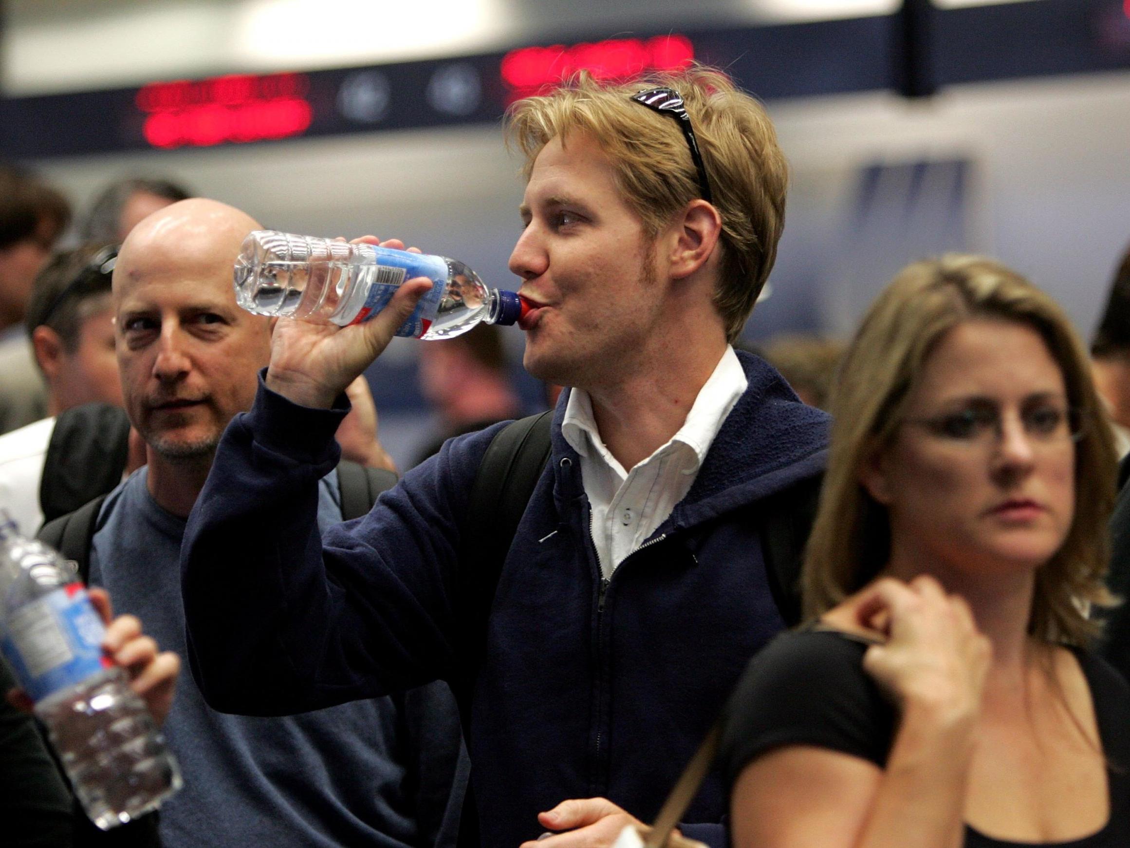 A man drinks from a plastic water bottle at San Francisco Airport