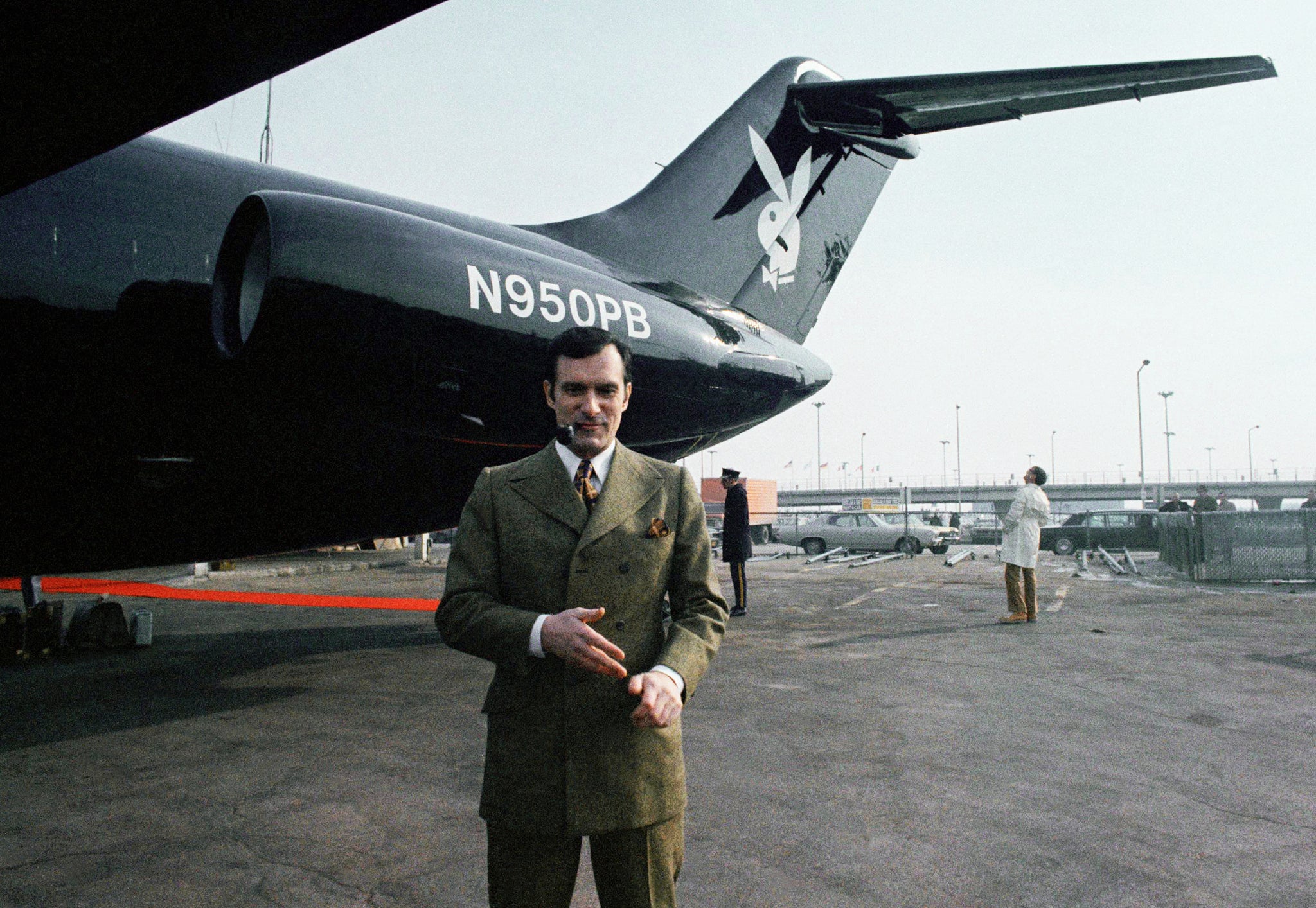 Hefner poses in front of his black jet plane in 1970