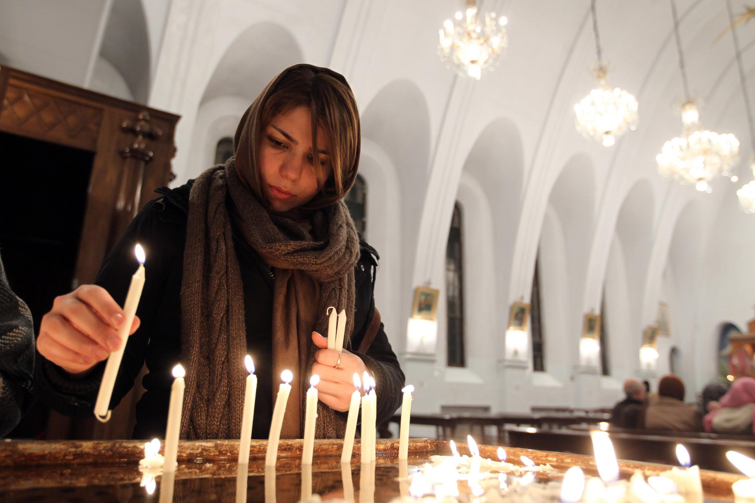 An Iranian Christian lights candles during the Christmas Eve mass at the St Gregor Armenian Catholic church in Tehran