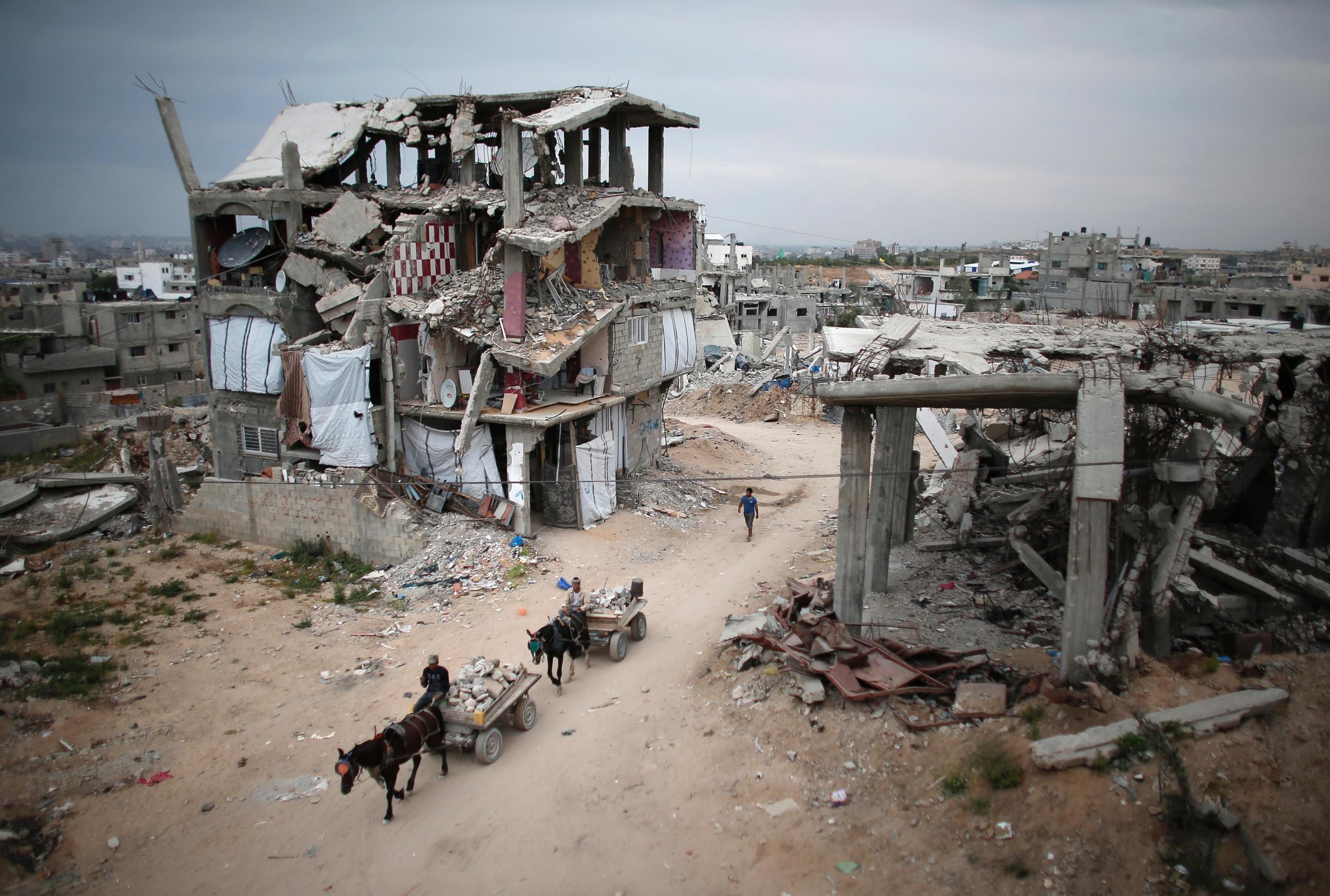 Palestinians ride through the rubble of buildings destroyed during the 50-day war between Hamas and Israel in 2014 (AFP/Getty)