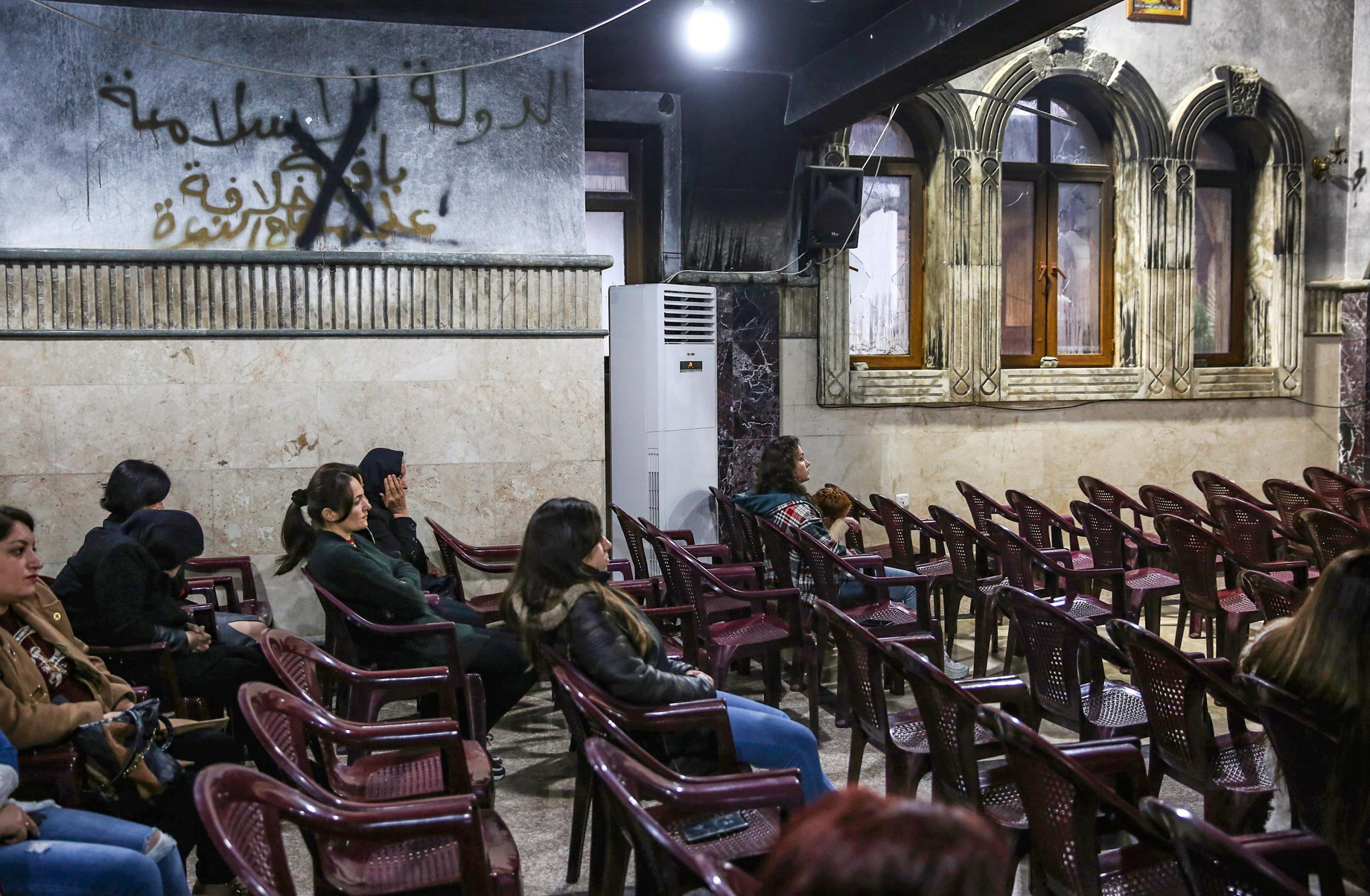 Christian worshippers attend Christmas mass at the Mar Behnam and Mart Sarah Syriac Catholic Church, which was damaged and defaced during its occupation by Isis (AFP/Getty)