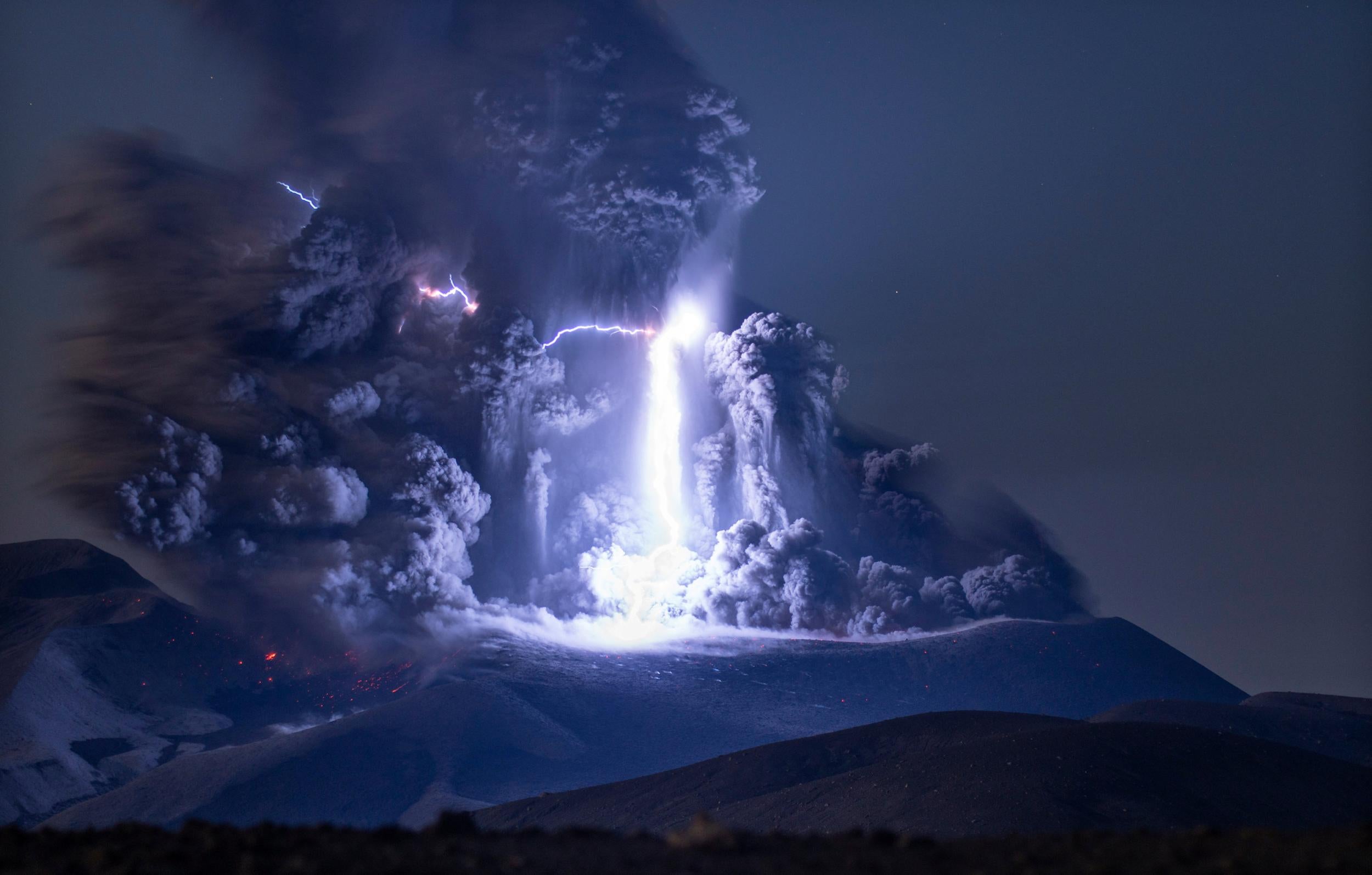 The Ebeko volcano erupts as a lightning bolt strikes the centre of the mountain