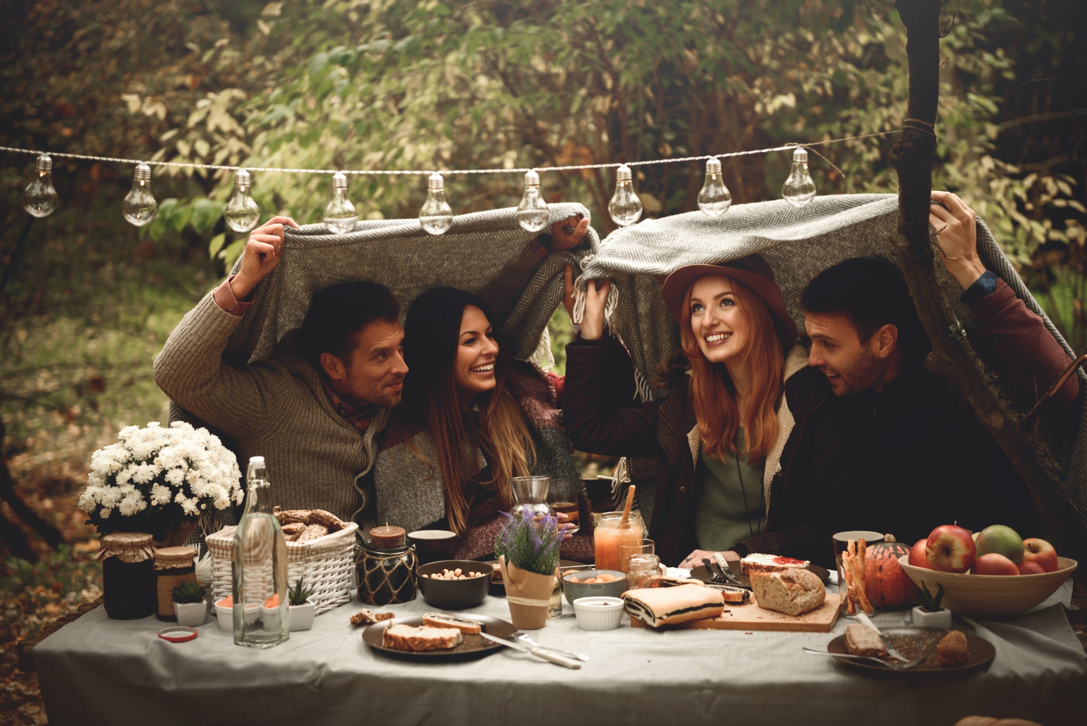 Friends hiding under a blanket