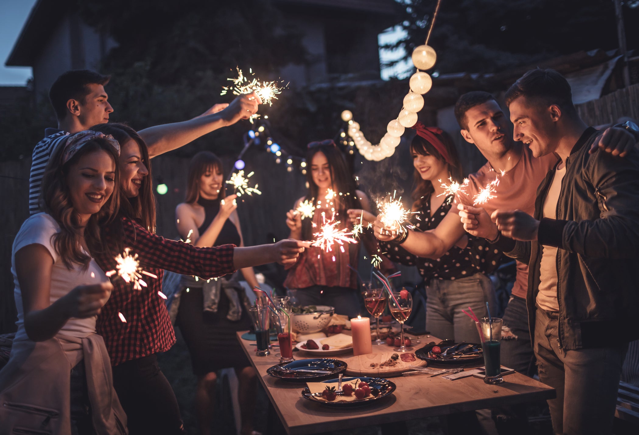 Group of friends having dinner party in backyard