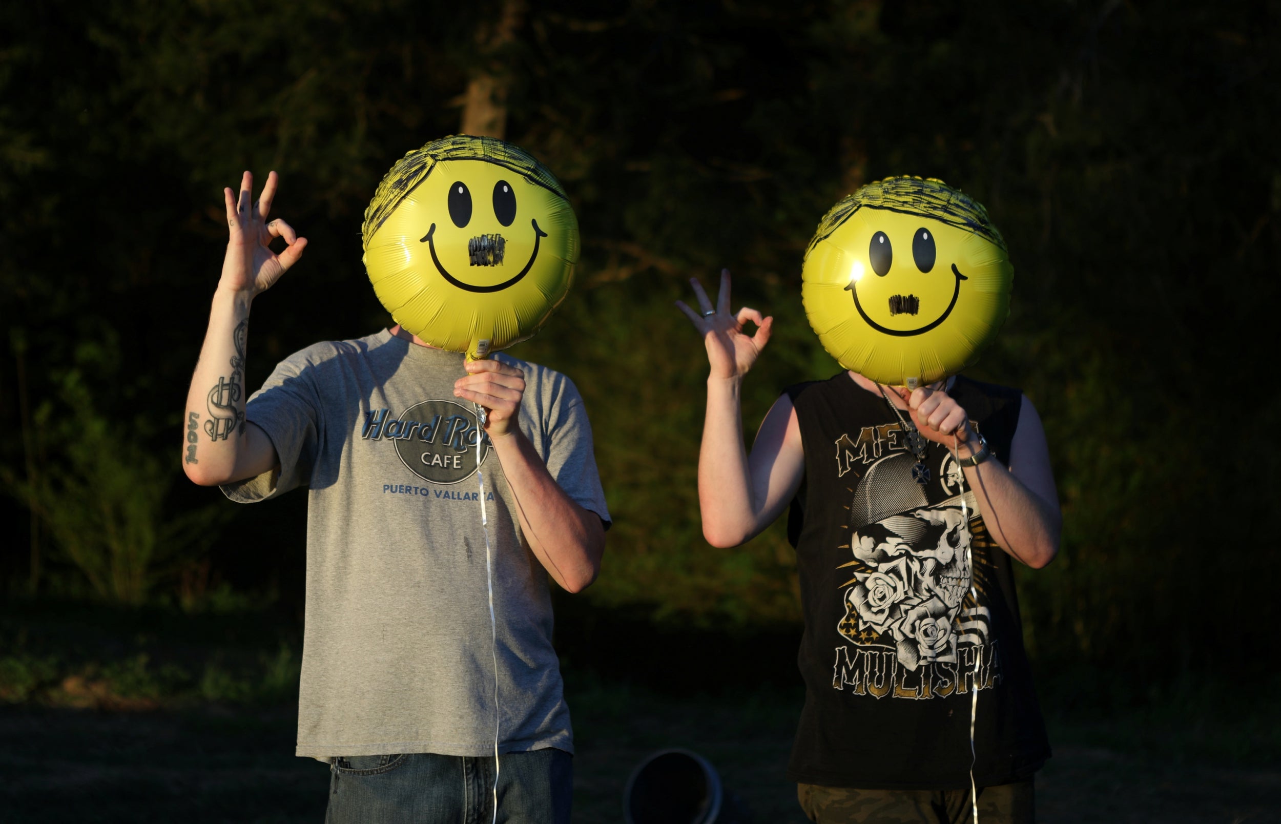 Members of the ShieldWall Network hold up balloons decorated as the face of Adolf Hitler and give a white-power hand signal as they celebrate the German fascist's birthday outside Atkins, Arkansas