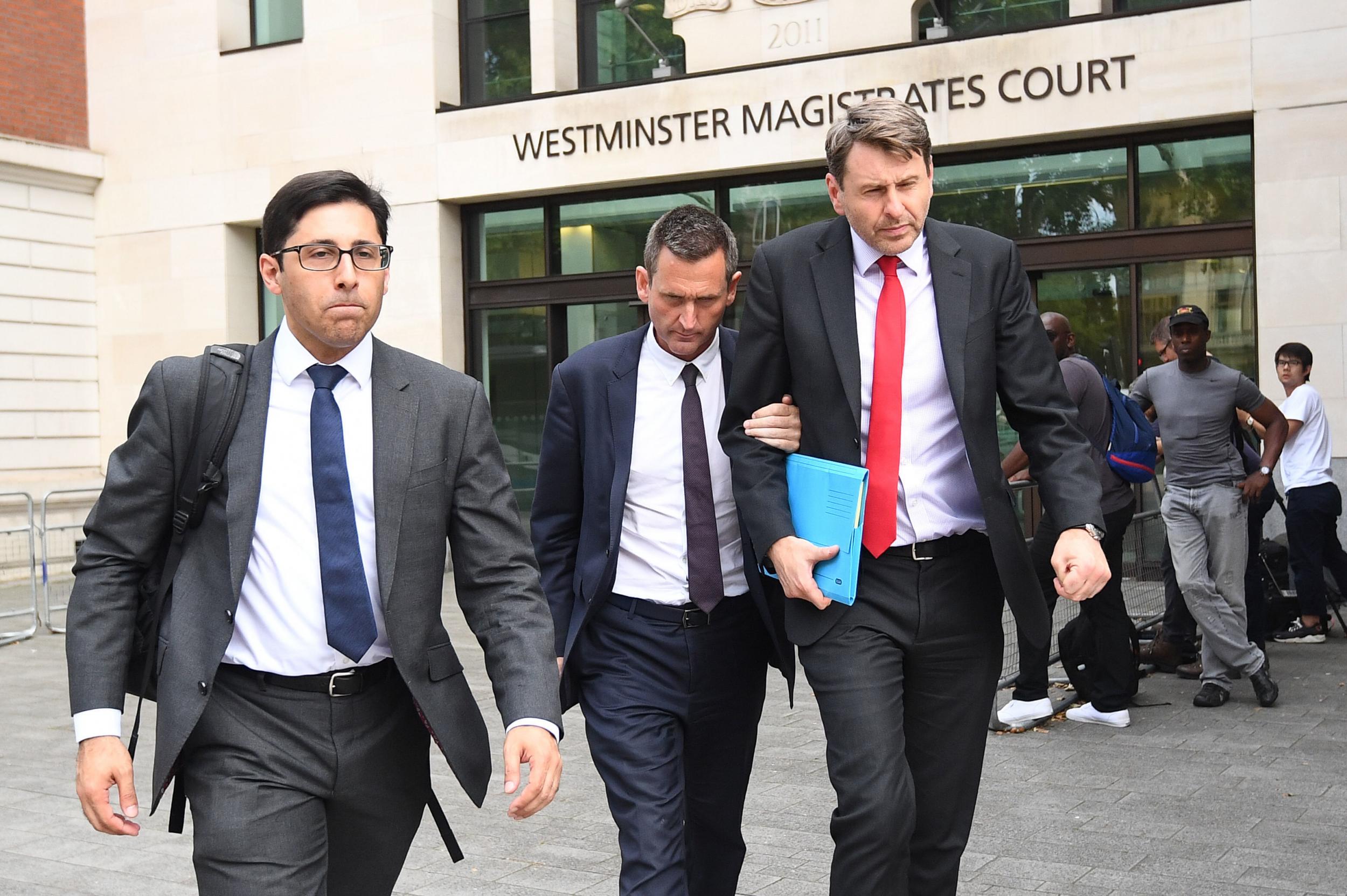 Lord Holmes of Richmond (centre) leaves Westminster Magistrates' Court following a previous hearing