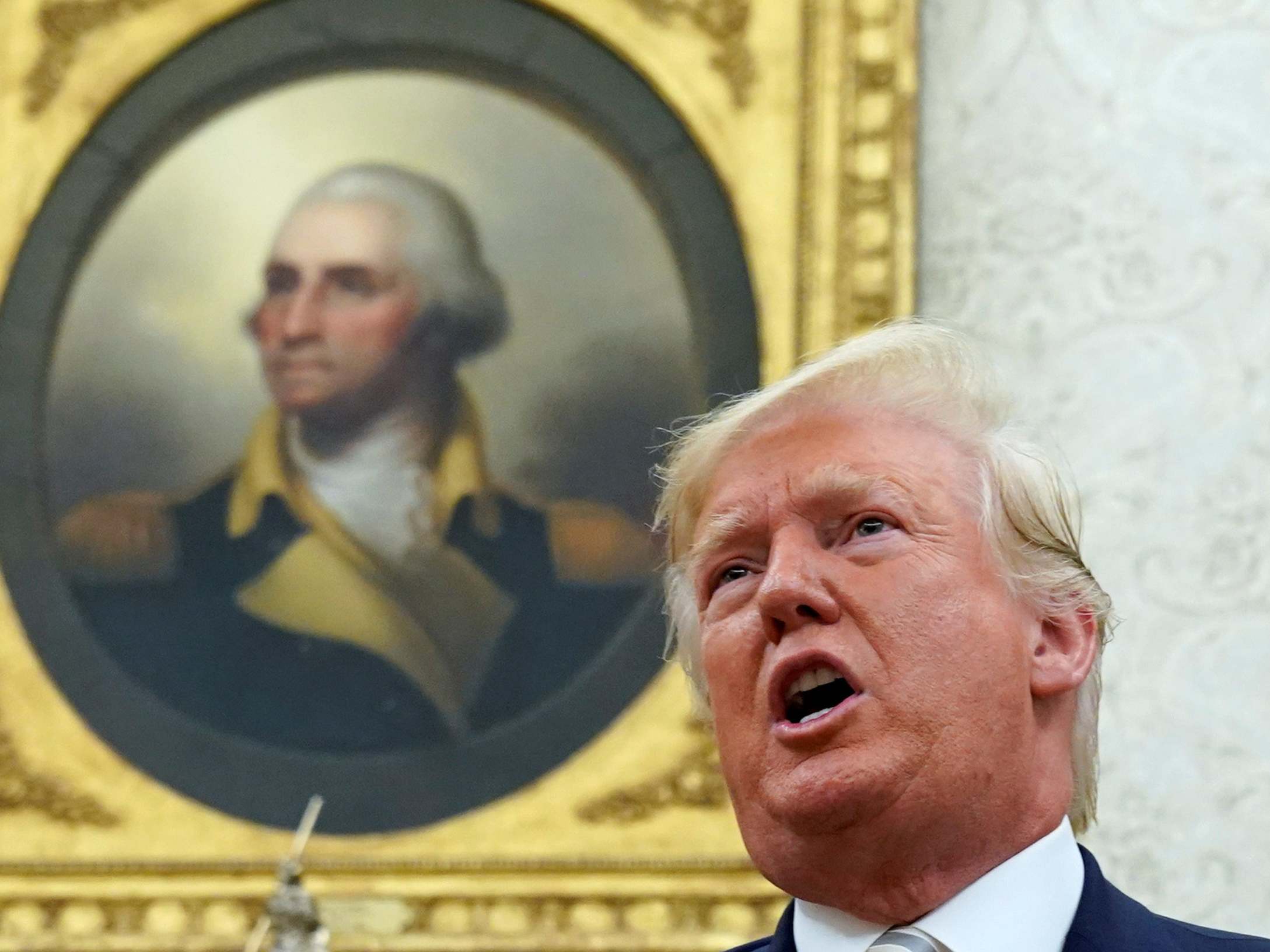 George Washington's portrait looks down on Donald Trump in the Oval Office