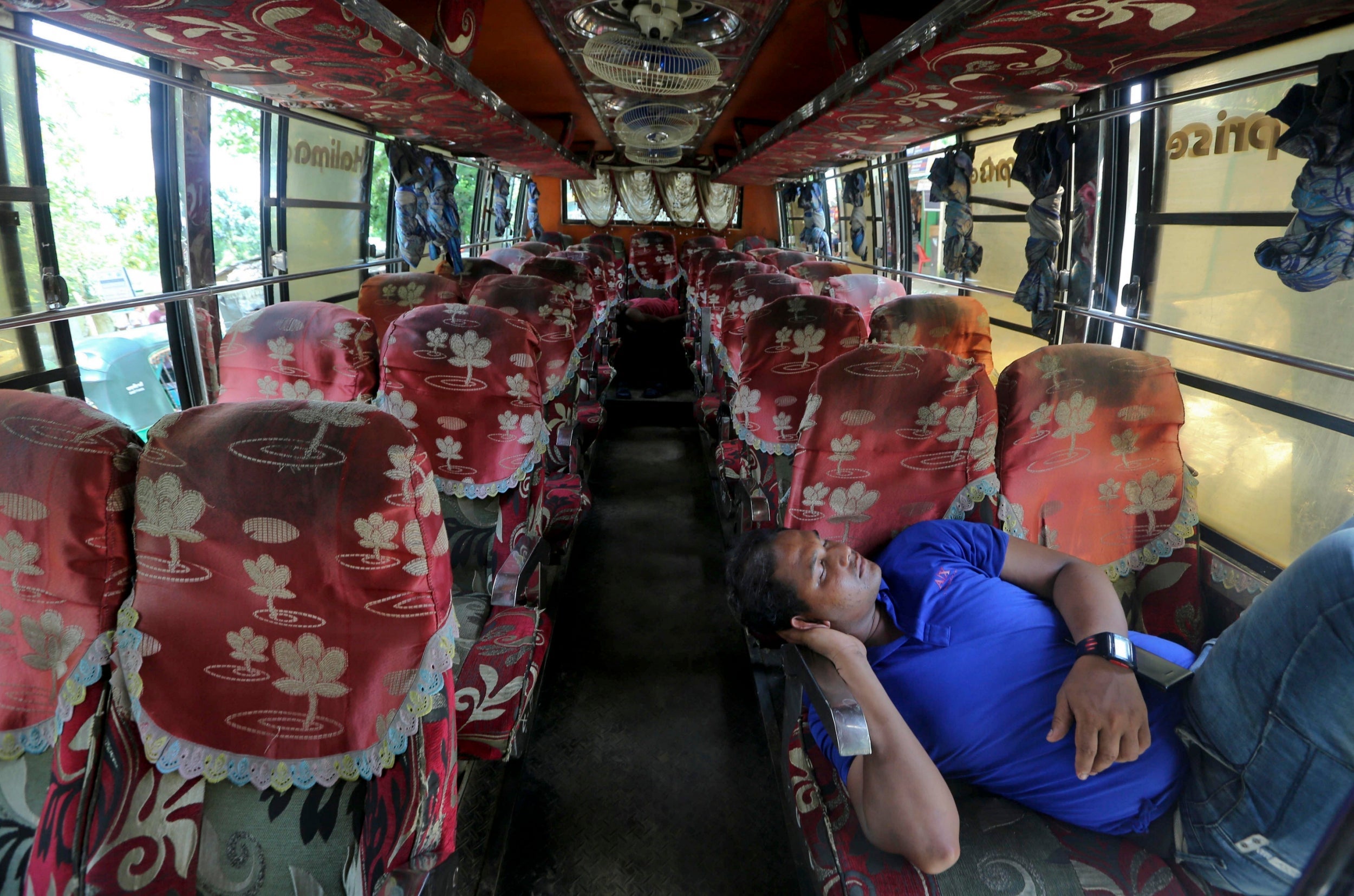 A driver waits on board a bus to take Rohingya refugees to the Myanmar border