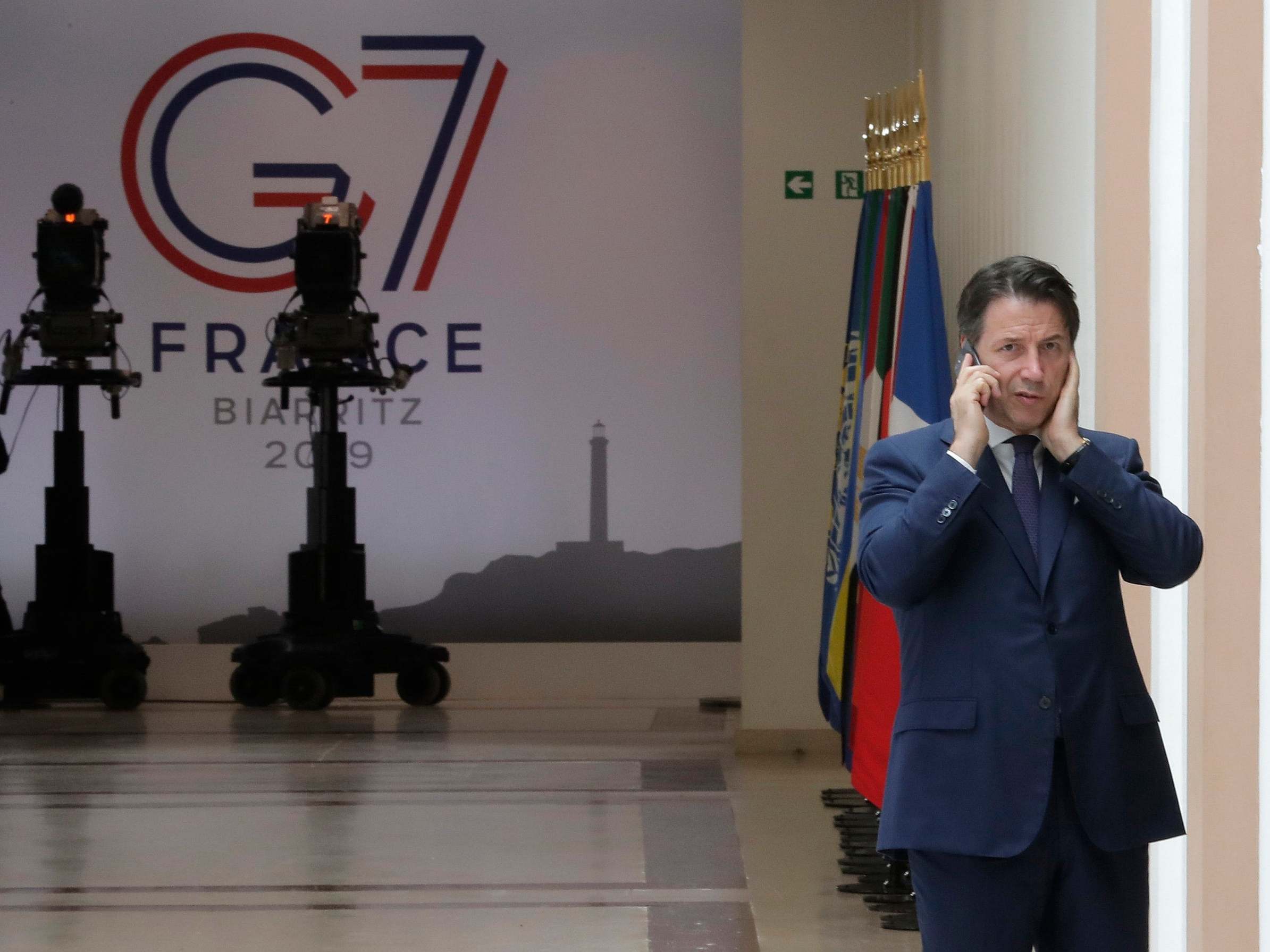 Italian premier Giuseppe Conte speaks on the phone on the second day of the G7 summit in Biarritz before leaving for talks in Rome