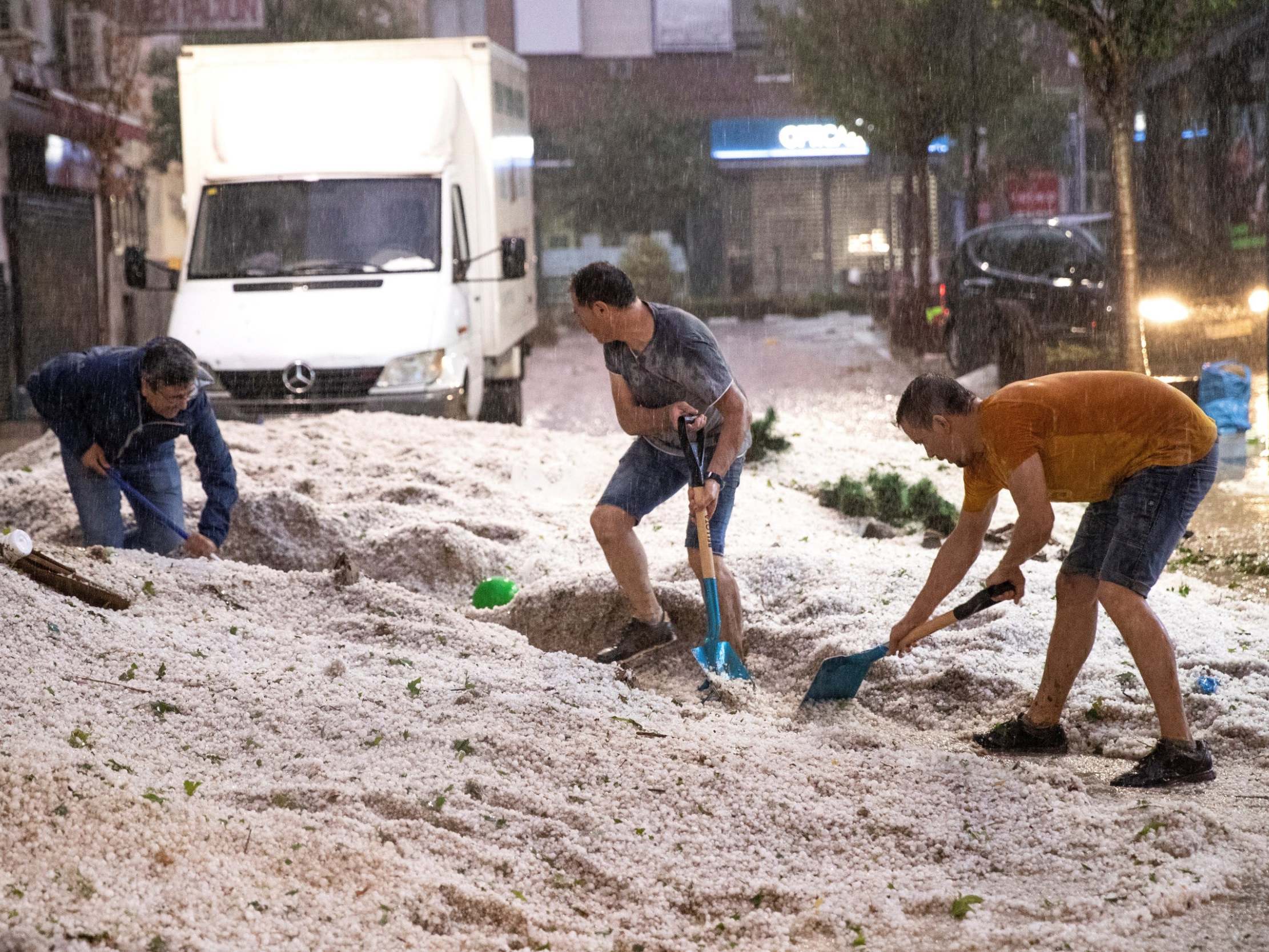 People remove hail from streets in Arganda del Rey, Madrid, Spain, 26 August 2019.