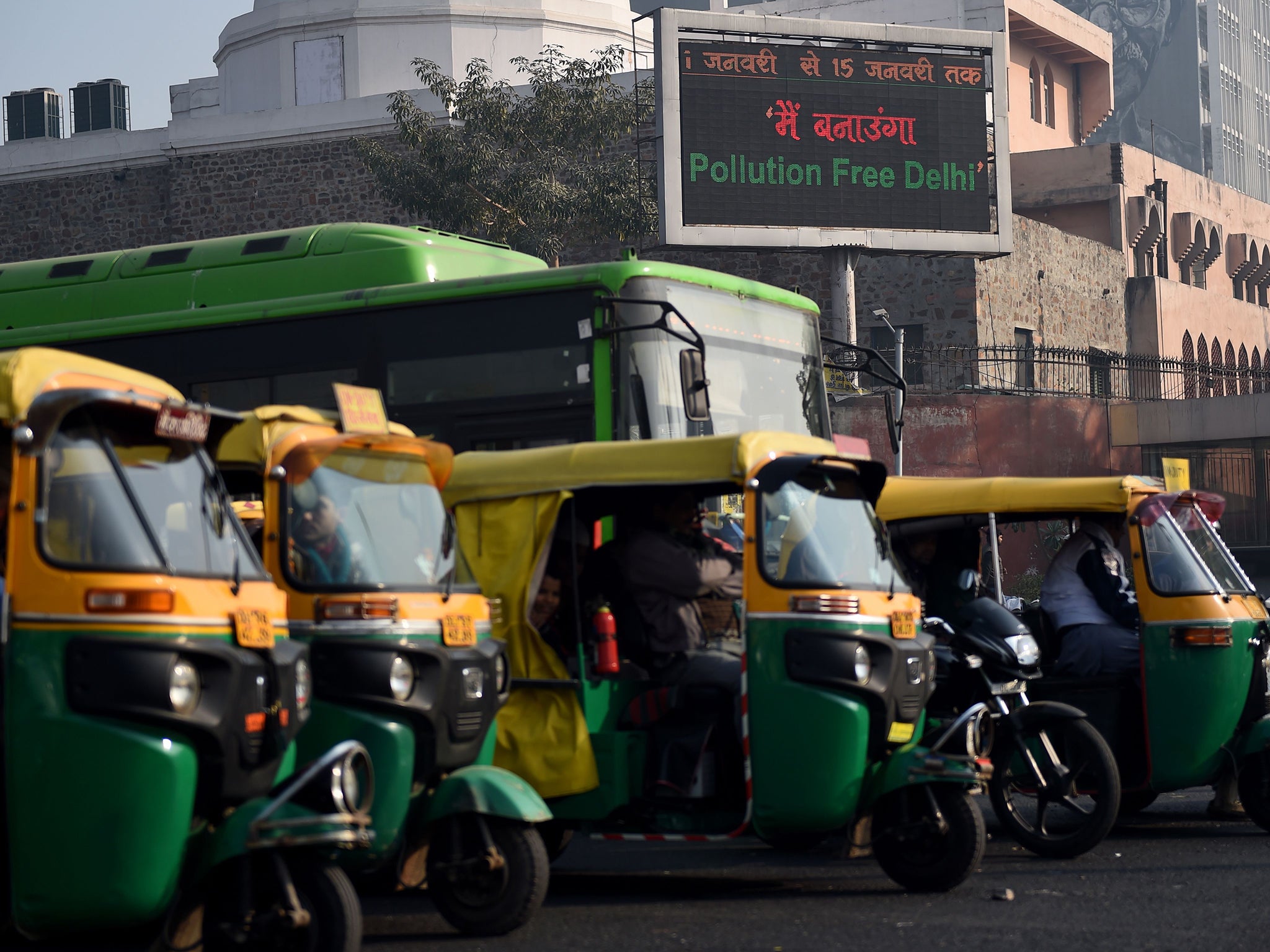 Rickshaws wait at a traffic intersection in New Delhi