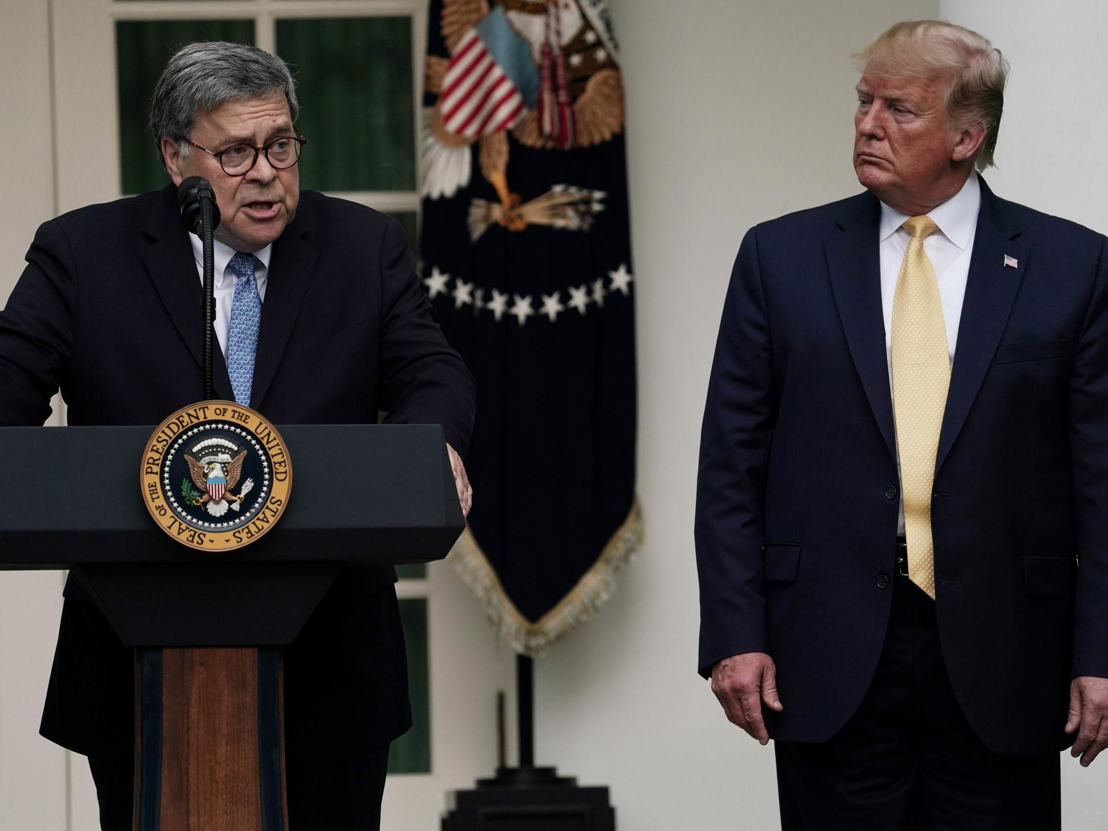 Attorney General William Barr speaks as Donald Trump looks on.