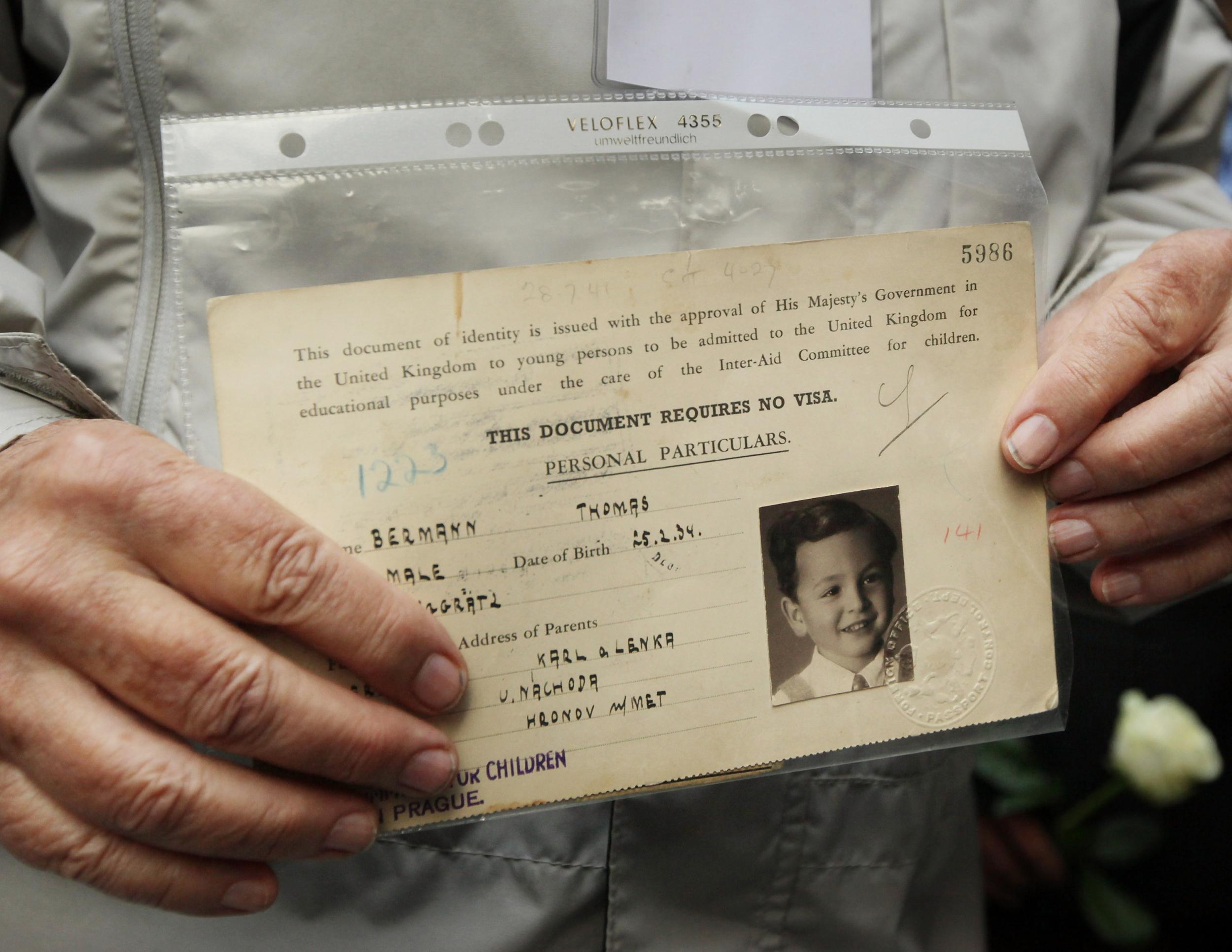 Czech evacuee Thomas Bermann holds his original British identity document at Liverpool Street station as part of a reenactment in September 2009 (Getty)