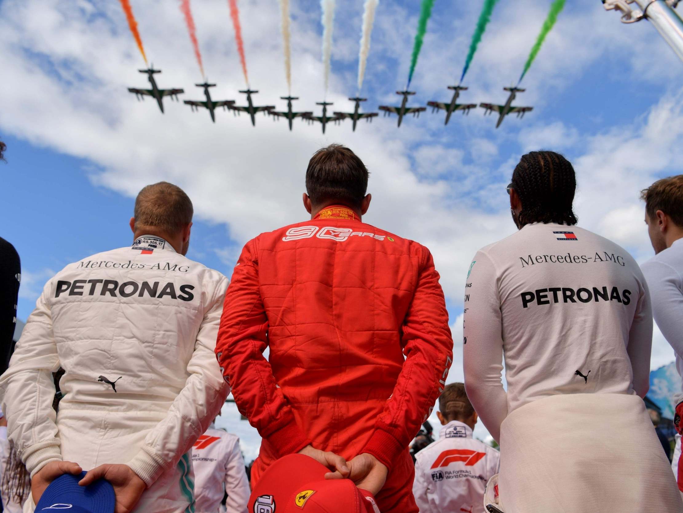 Charles Leclerc stands between Valtteri Bottas and Lewis Hamilton on the podium